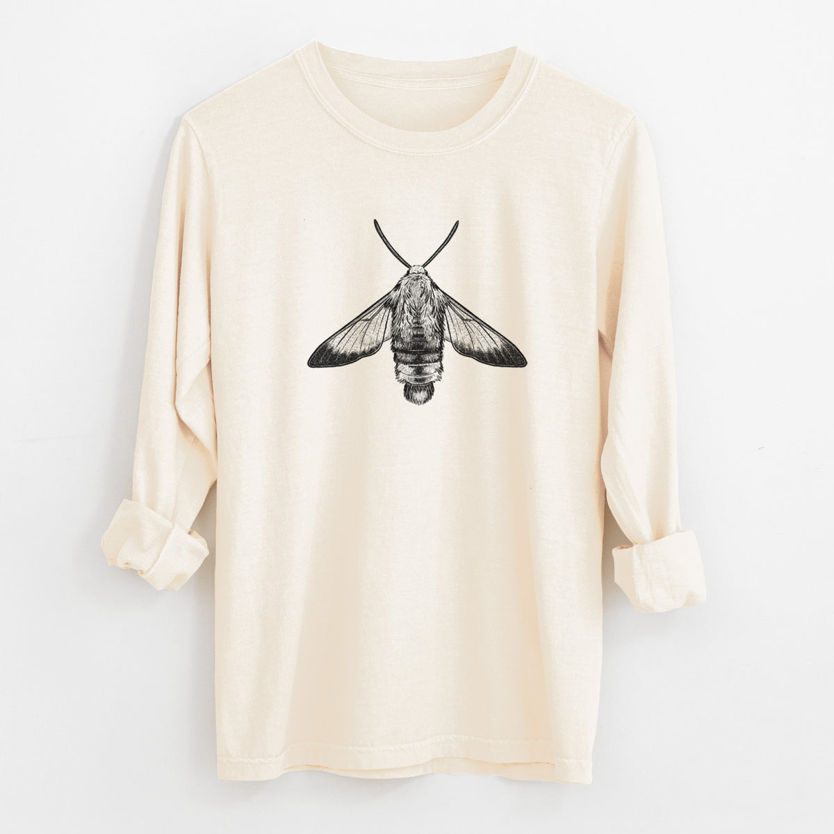 Ivory Comfort Colors long sleeve shirt laid flat with the cuffs rolled, printed with a detailed black ink illustration of a snowberry clearwing moth, seen from above.