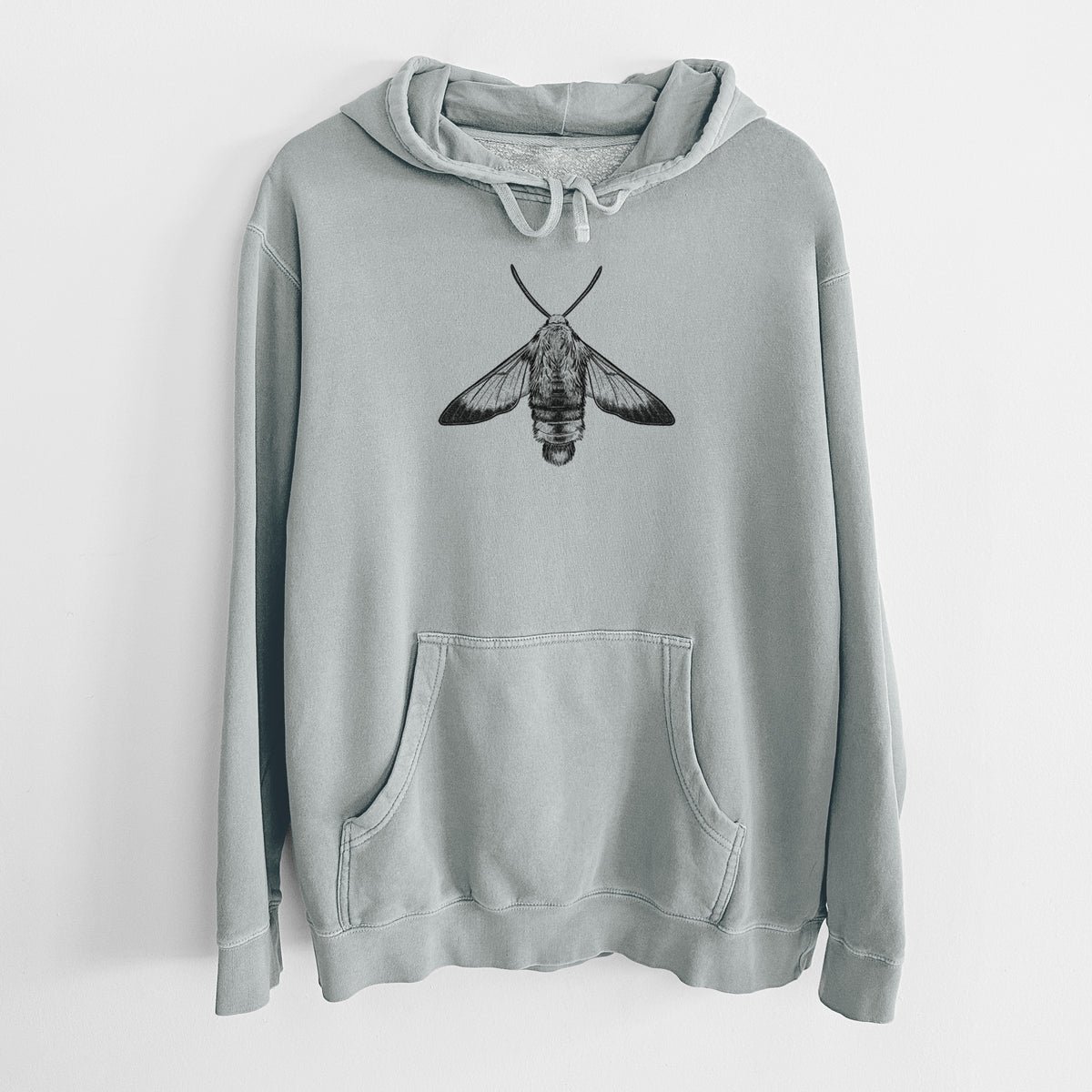 Sage green pigment dyed hoodie laid flat, printed with a detailed black ink illustration of a snowberry clearwing moth, seen from above.