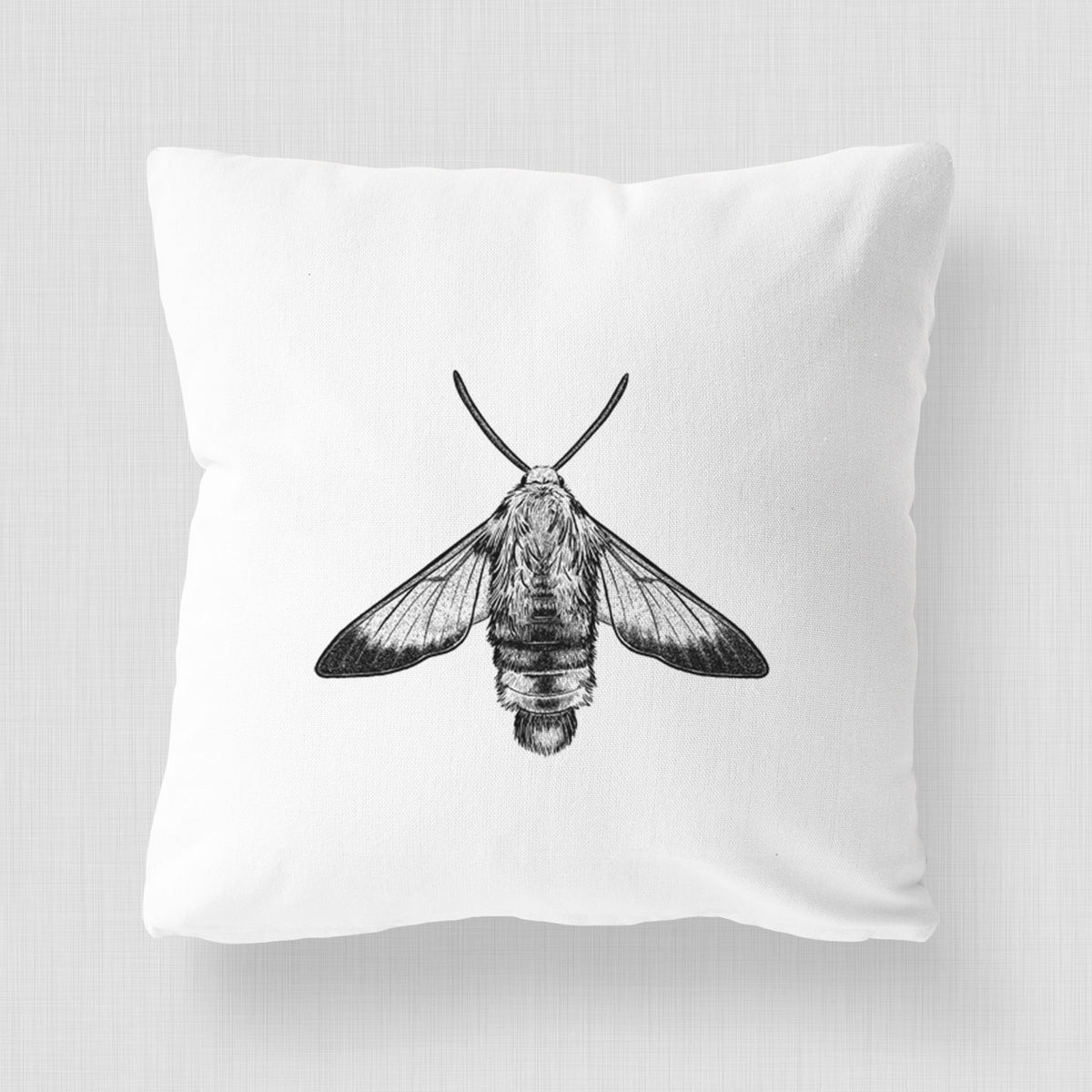 White pillow cover printed with a detailed black ink illustration of a snowberry clearwing moth, seen from above.