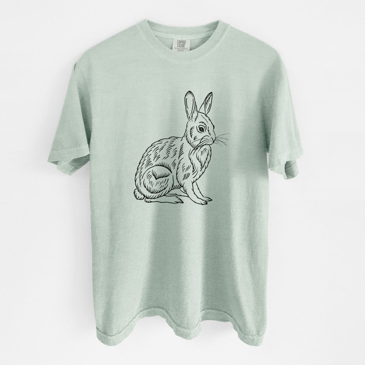 Bay green Comfort Colors t-shirt laid flat, printed with a detailed black ink illustration of a snowshoe hare sitting upright.