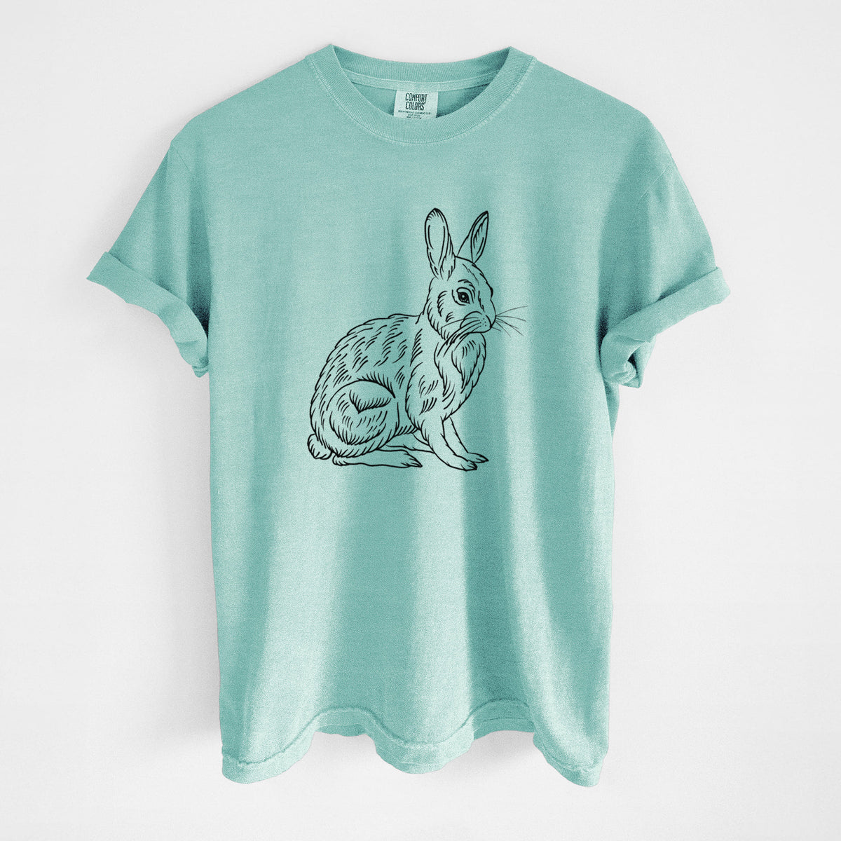 Chalky mint Comfort Colors t-shirt laid flat, printed with a detailed black ink illustration of a snowshoe hare sitting upright.
