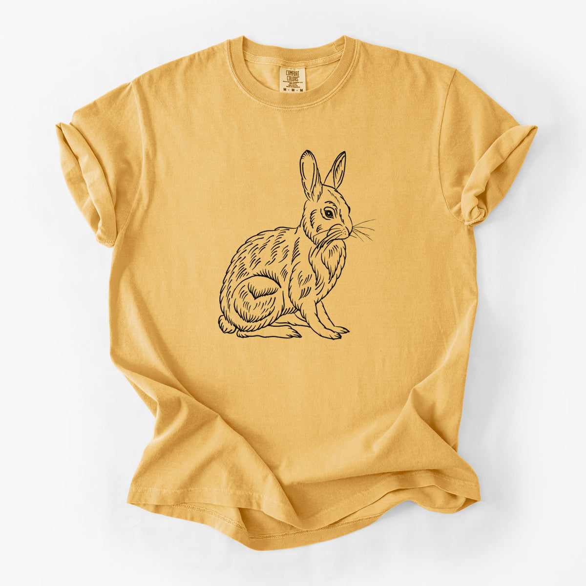Golden wheat yellow Comfort Colors t-shirt laid flat, printed with a detailed black ink illustration of a snowshoe hare sitting upright.