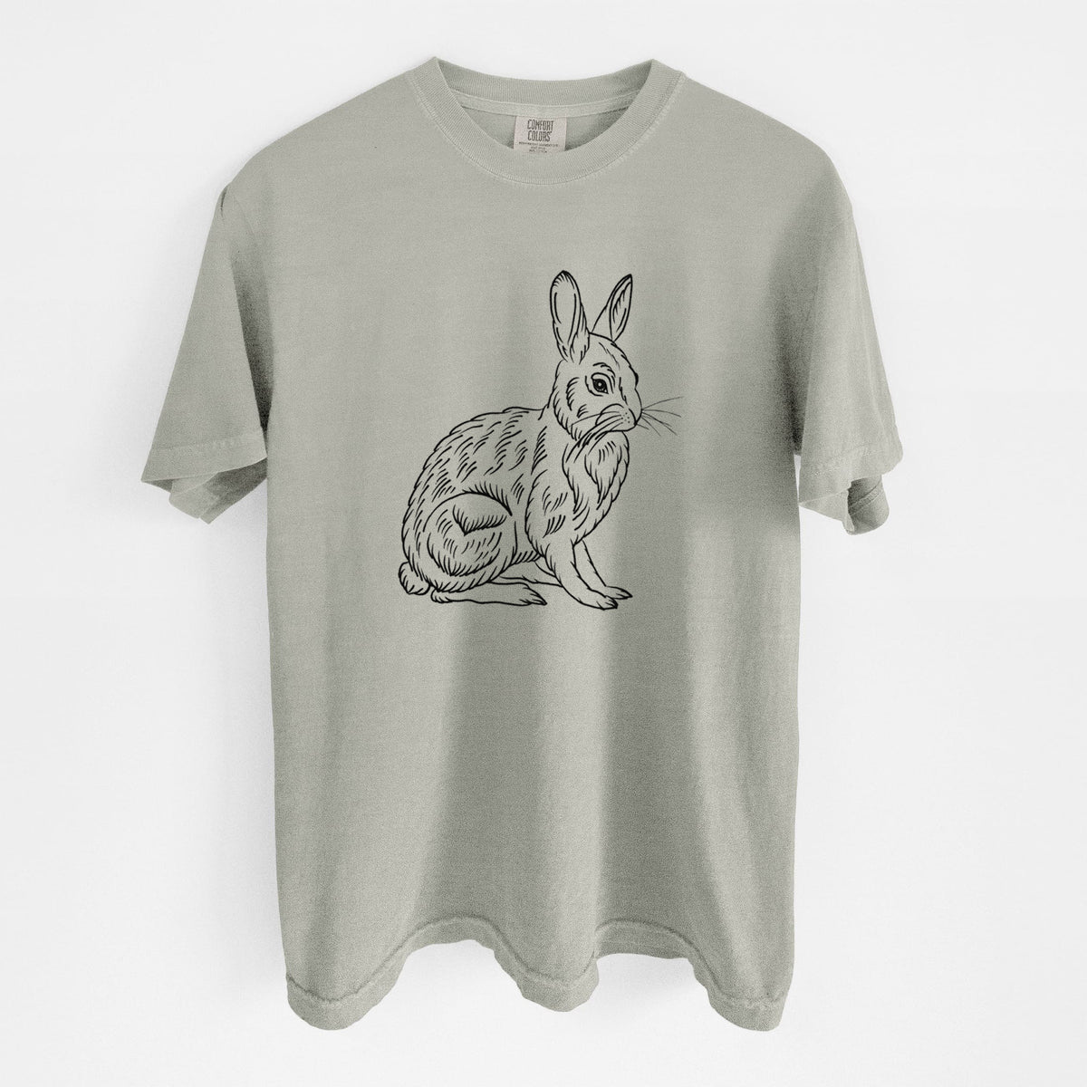 Sandstone beige Comfort Colors t-shirt laid flat, printed with a detailed black ink illustration of a snowshoe hare sitting upright.