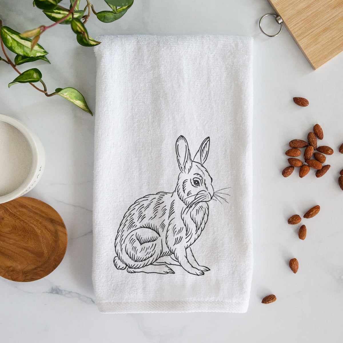 White hand towel printed with a detailed black ink illustration of a snowshoe hare sitting upright.