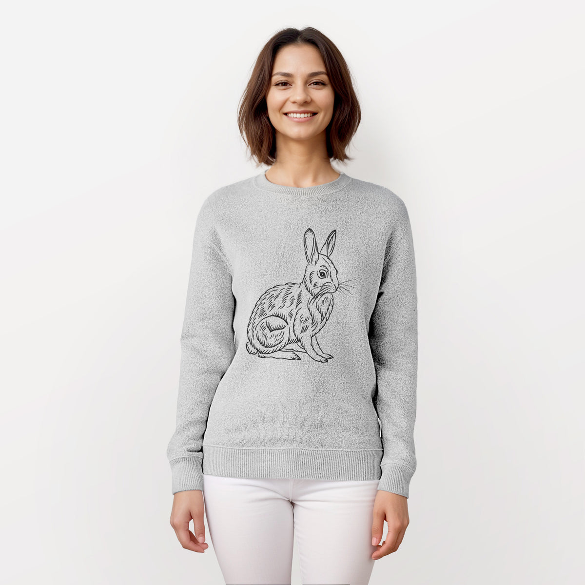 Woman wearing a knit sweatshirt printed with a detailed black ink illustration of a snowshoe hare sitting upright.
