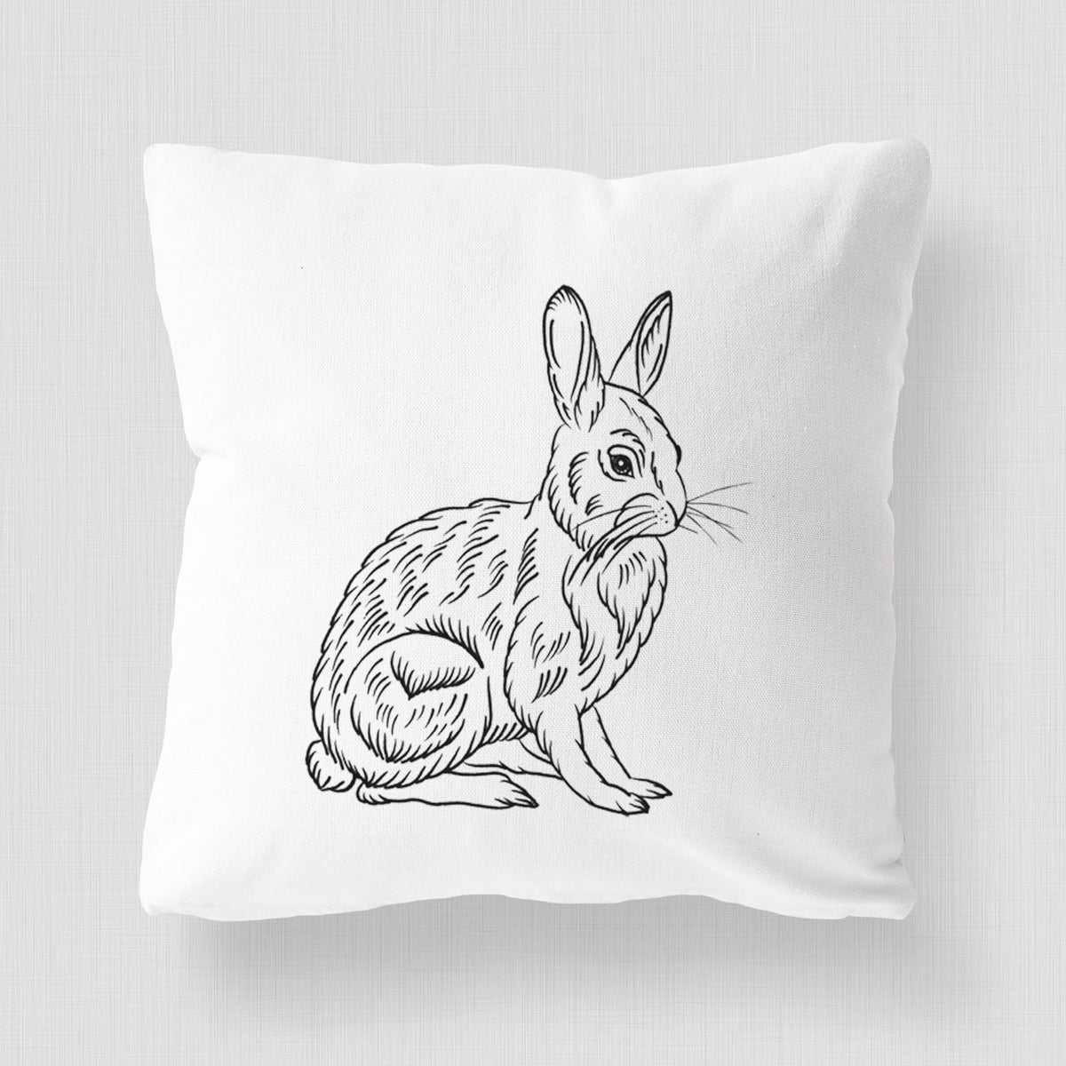 White pillow cover printed with a detailed black ink illustration of a snowshoe hare sitting upright.