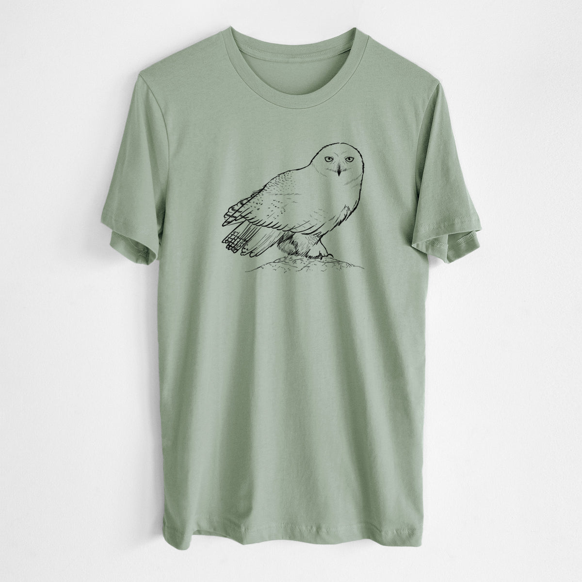Sage green lightweight cotton t-shirt laid flat, printed with a detailed black ink illustration of a snowy owl perched on a snowy mound.