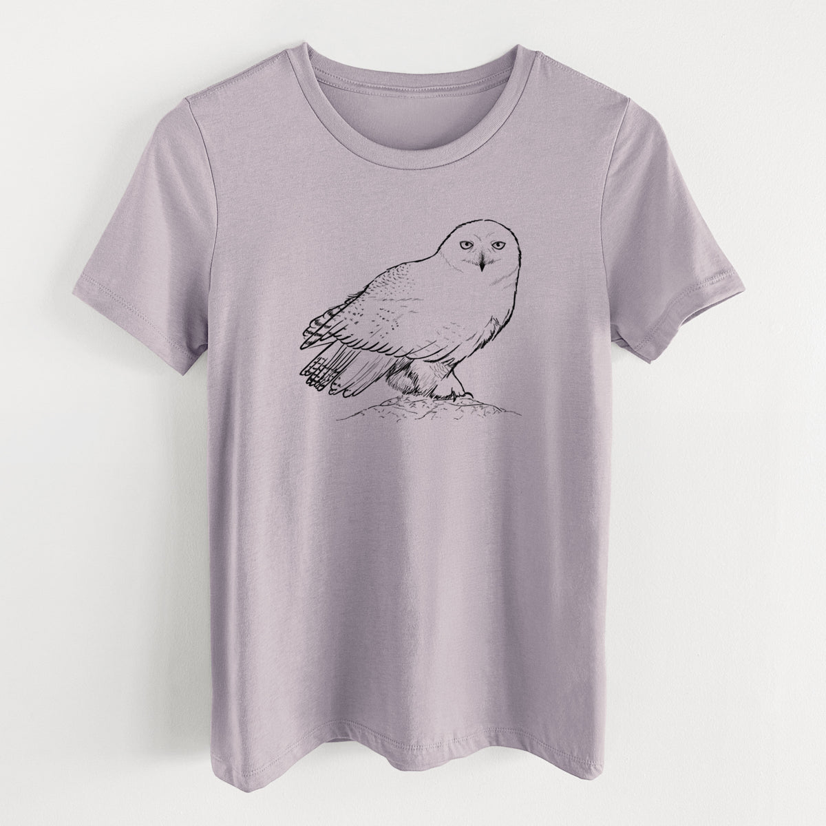 Light violet women's relaxed fit cotton t-shirt laid flat, printed with a detailed black ink illustration of a snowy owl perched on a snowy mound.