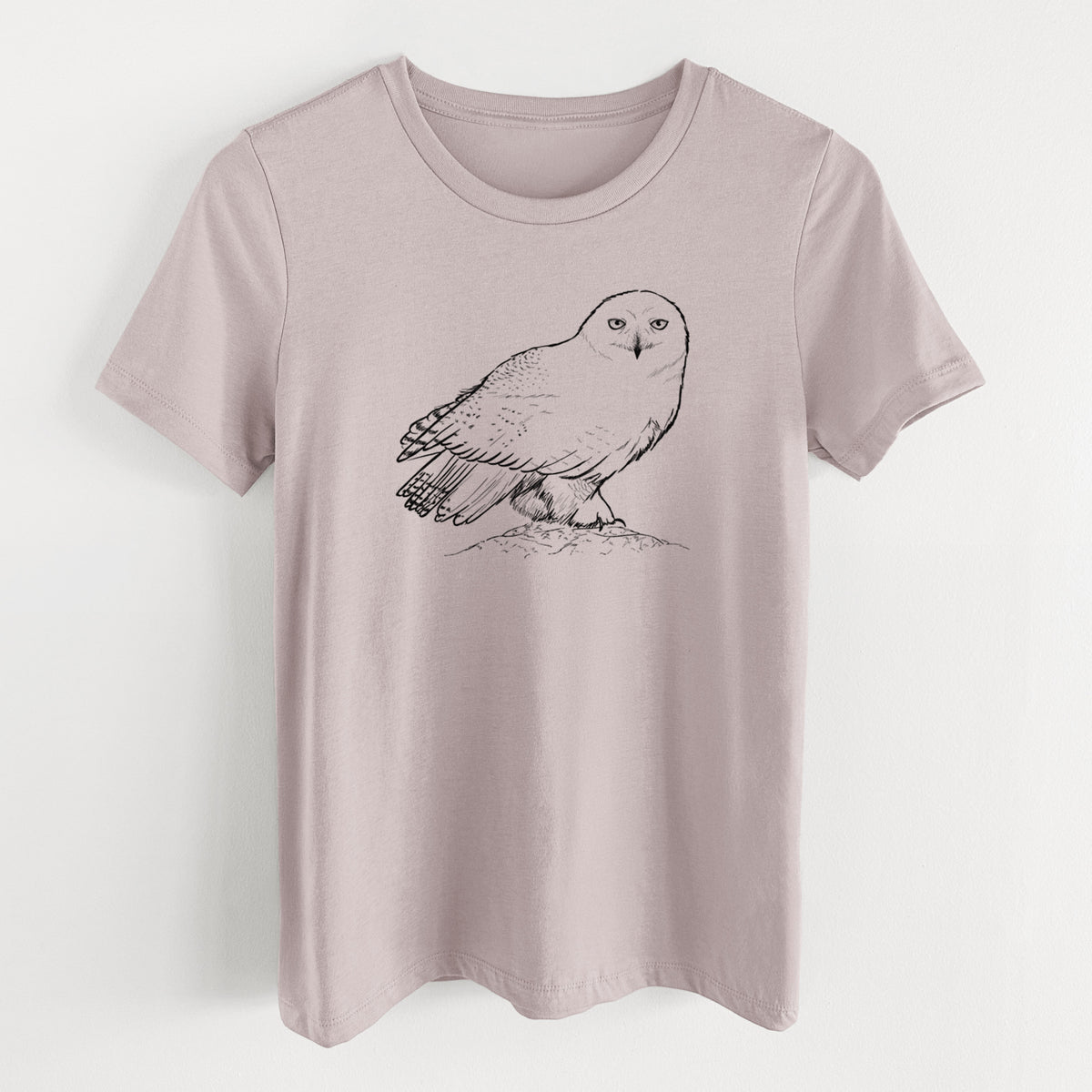 Pink gravel women's relaxed fit cotton t-shirt laid flat, printed with a detailed black ink illustration of a snowy owl perched on a snowy mound.