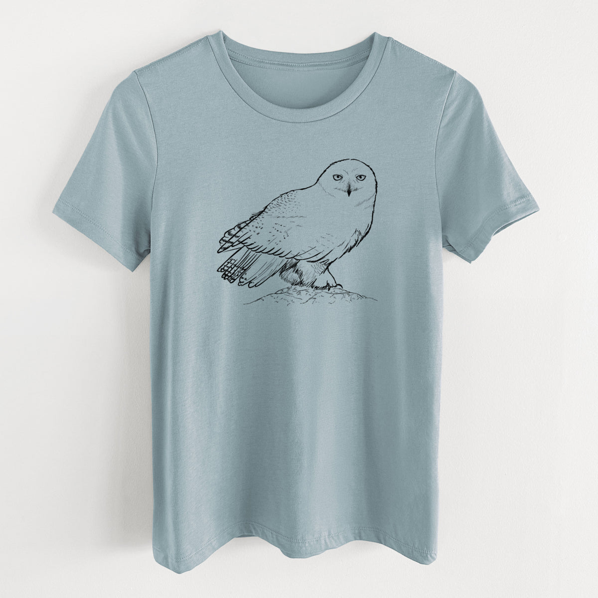 Vintage denim women's relaxed fit cotton t-shirt laid flat, printed with a detailed black ink illustration of a snowy owl perched on a snowy mound.