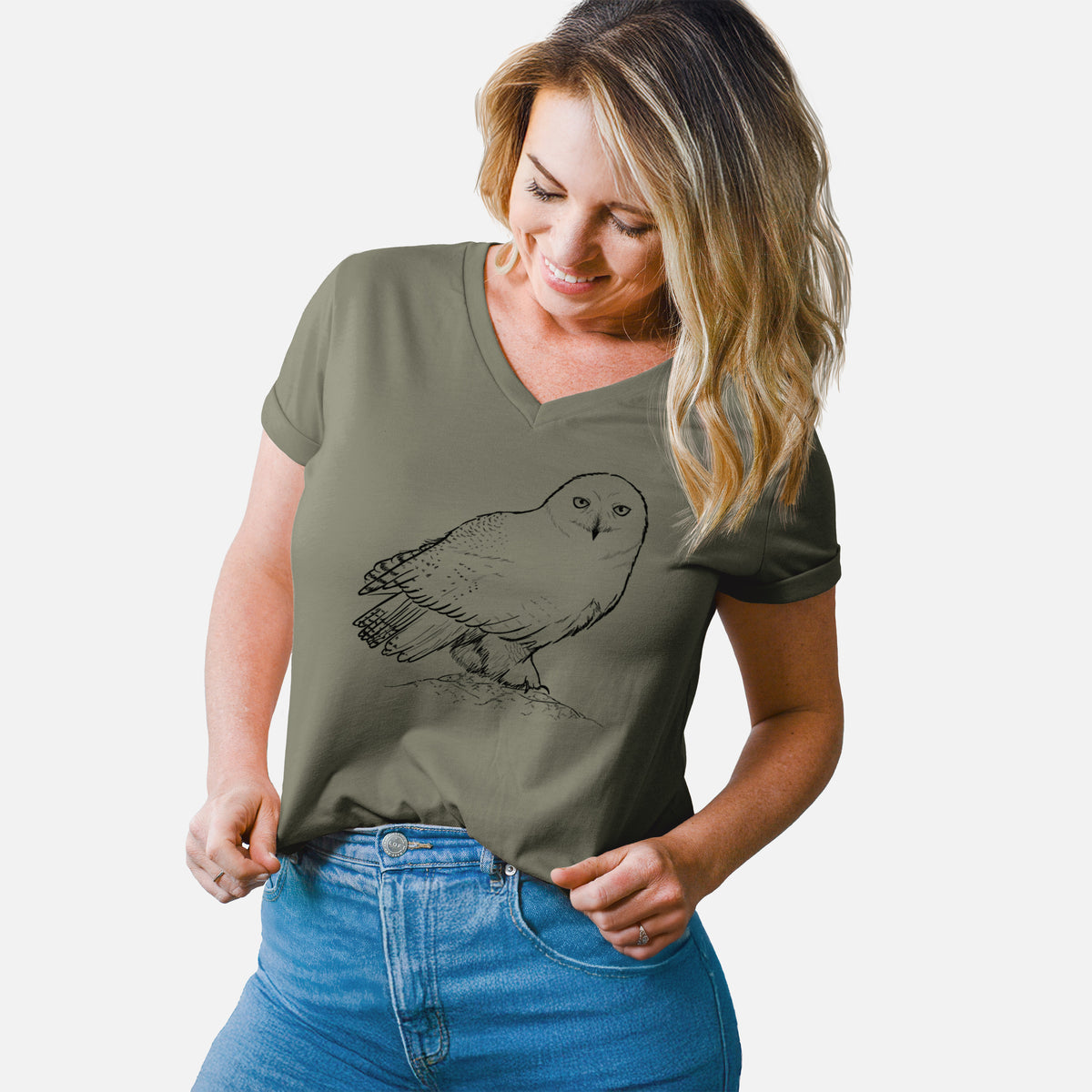 Woman wearing a military green women's relaxed fit cotton V-neck t-shirt printed with a detailed black ink illustration of a snowy owl perched on a snowy mound.