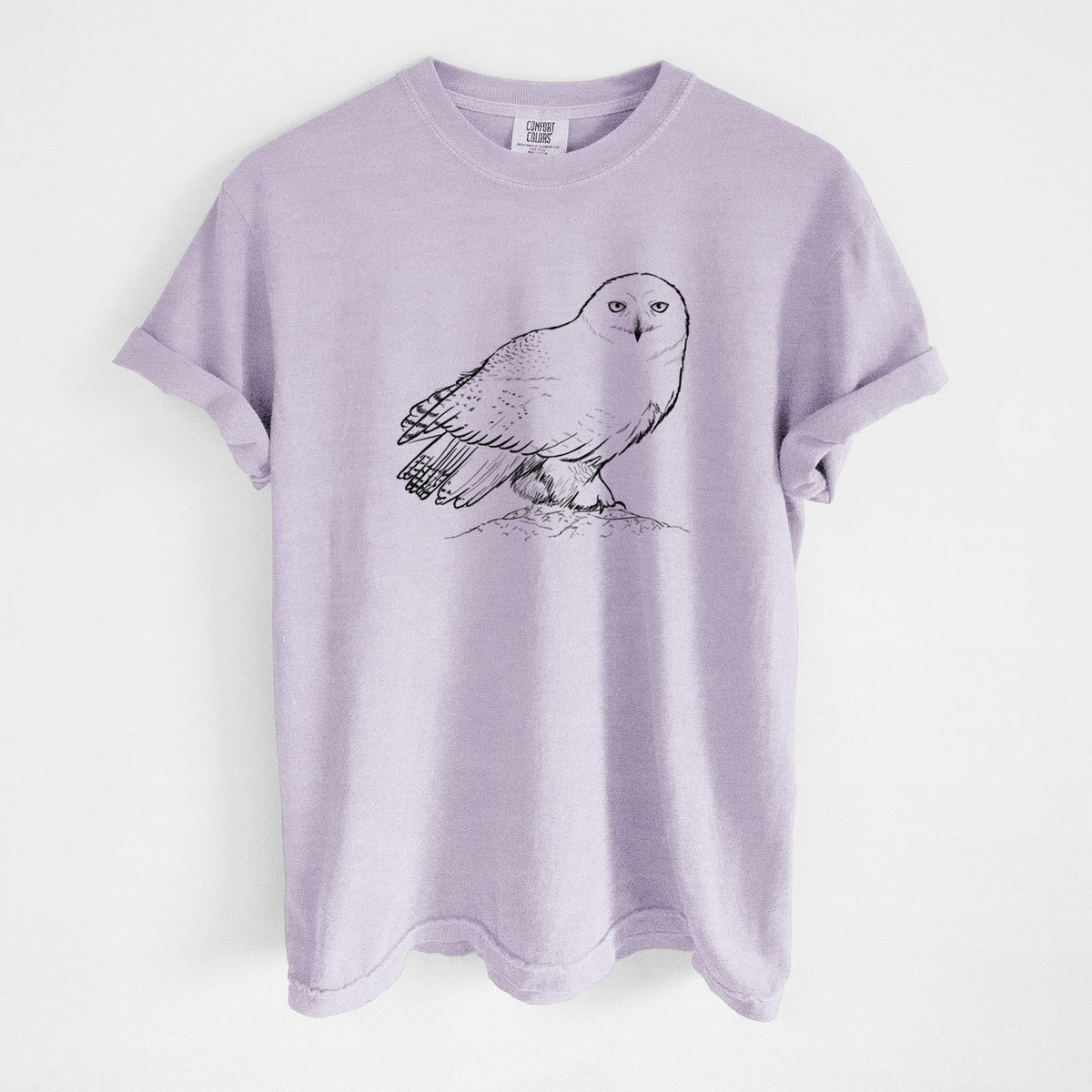 Orchid purple Comfort Colors t-shirt laid flat, printed with a detailed black ink illustration of a snowy owl perched on a snowy mound.