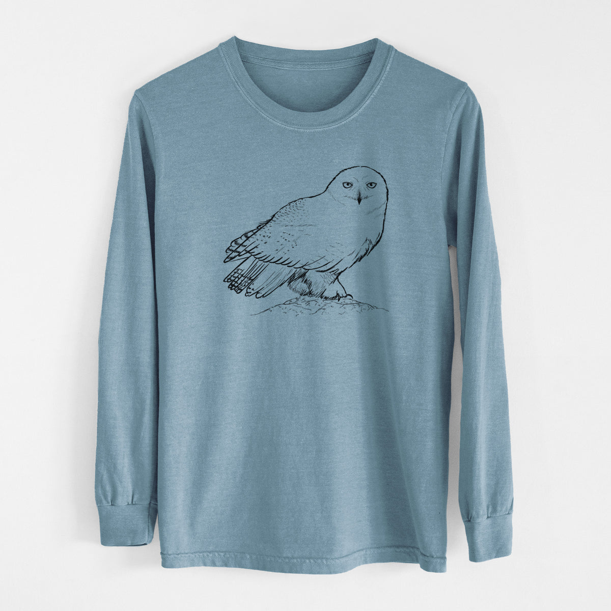 Steel blue Comfort Colors long sleeve shirt laid flat, printed with a detailed black ink illustration of a snowy owl perched on a snowy mound.