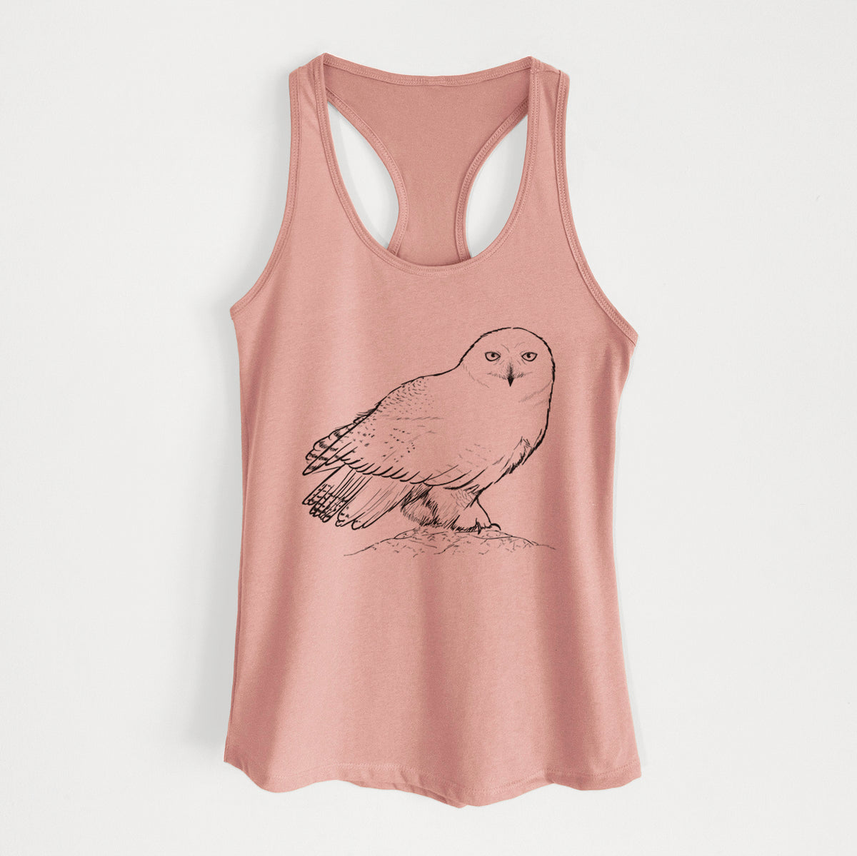 Desert pink women's racerback tank top laid flat, printed with a detailed black ink illustration of a snowy owl perched on a snowy mound.