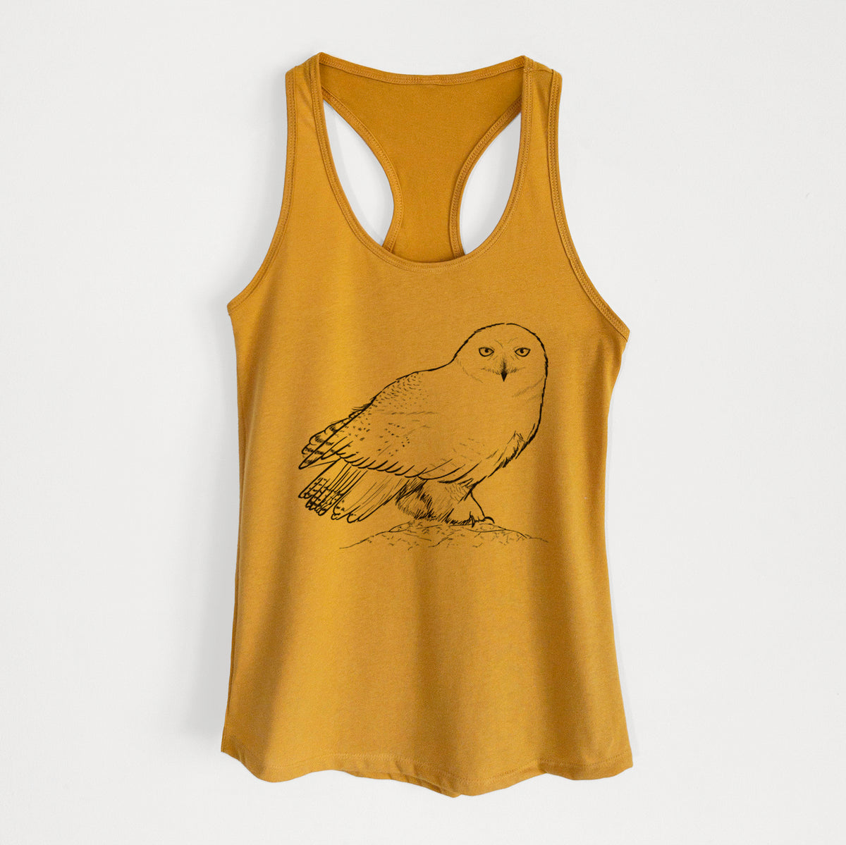 Gold women's racerback tank top laid flat, printed with a detailed black ink illustration of a snowy owl perched on a snowy mound.