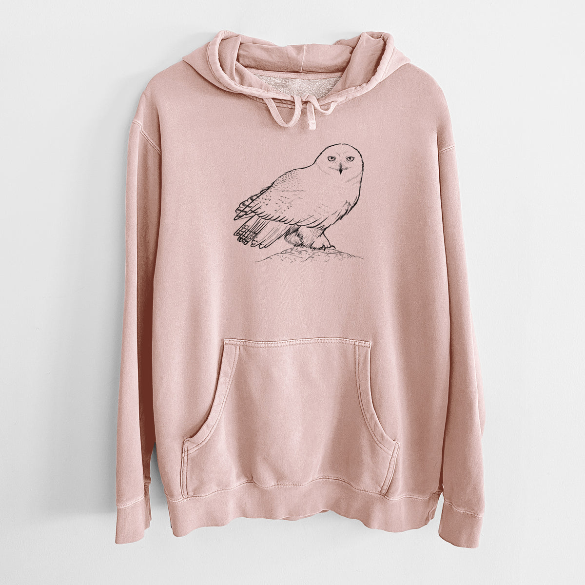 Dusty pink pigment dyed hoodie laid flat, printed with a detailed black ink illustration of a snowy owl perched on a snowy mound.