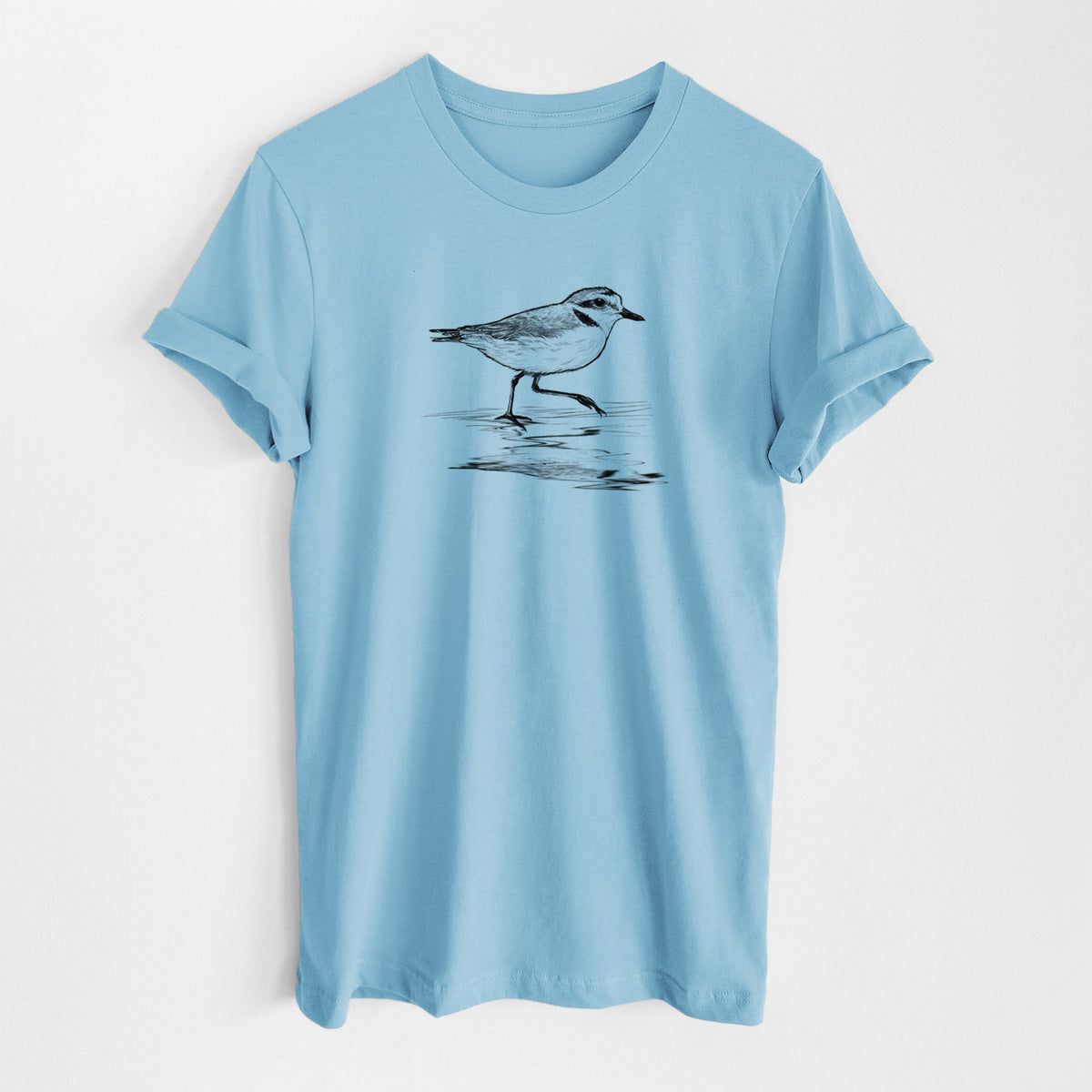 Ocean blue lightweight cotton t-shirt laid flat, printed with a black ink sketch of a snowy plover running along the wet shoreline.