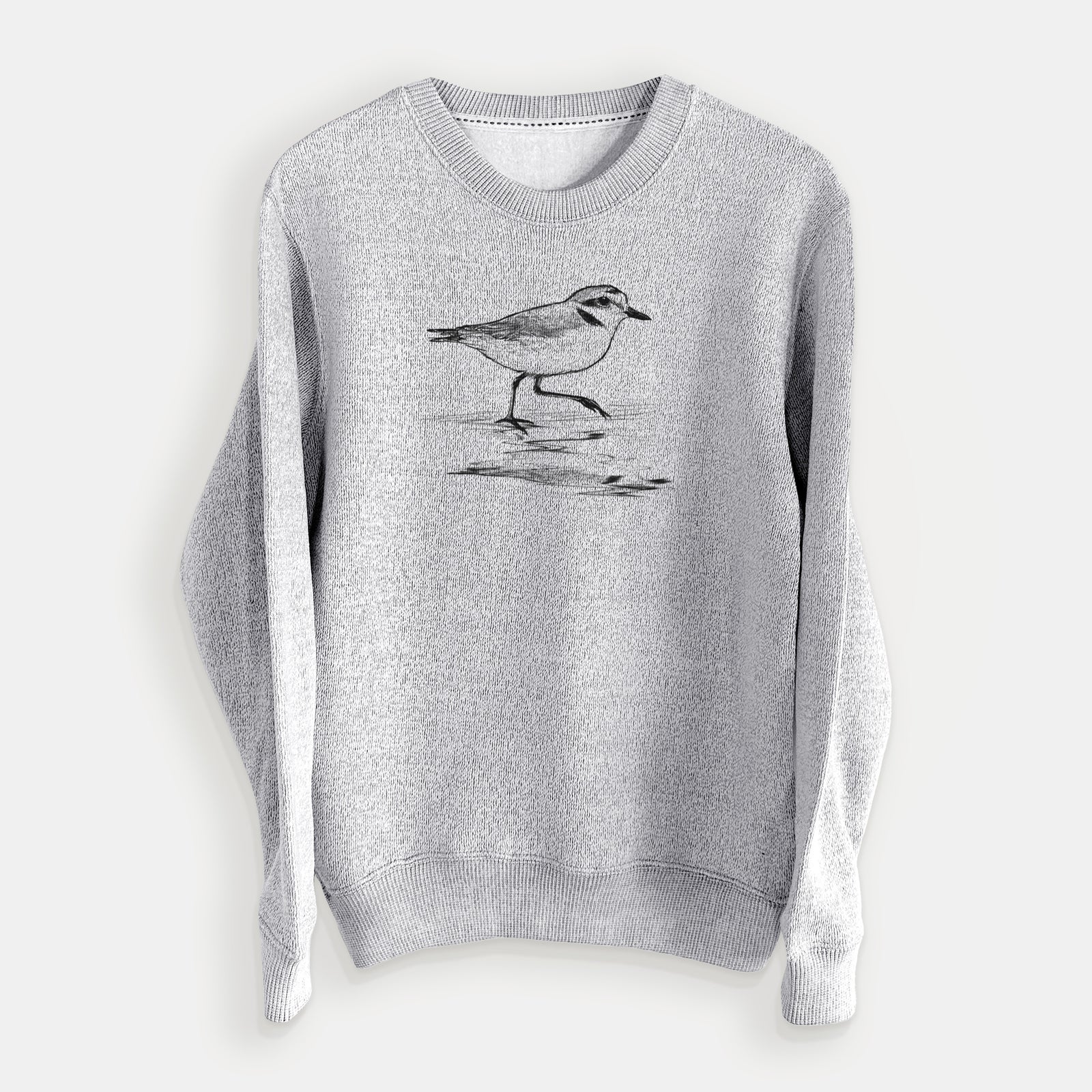 Salt and pepper knit sweatshirt laid flat, printed with a black ink sketch of a snowy plover running along the wet shoreline.