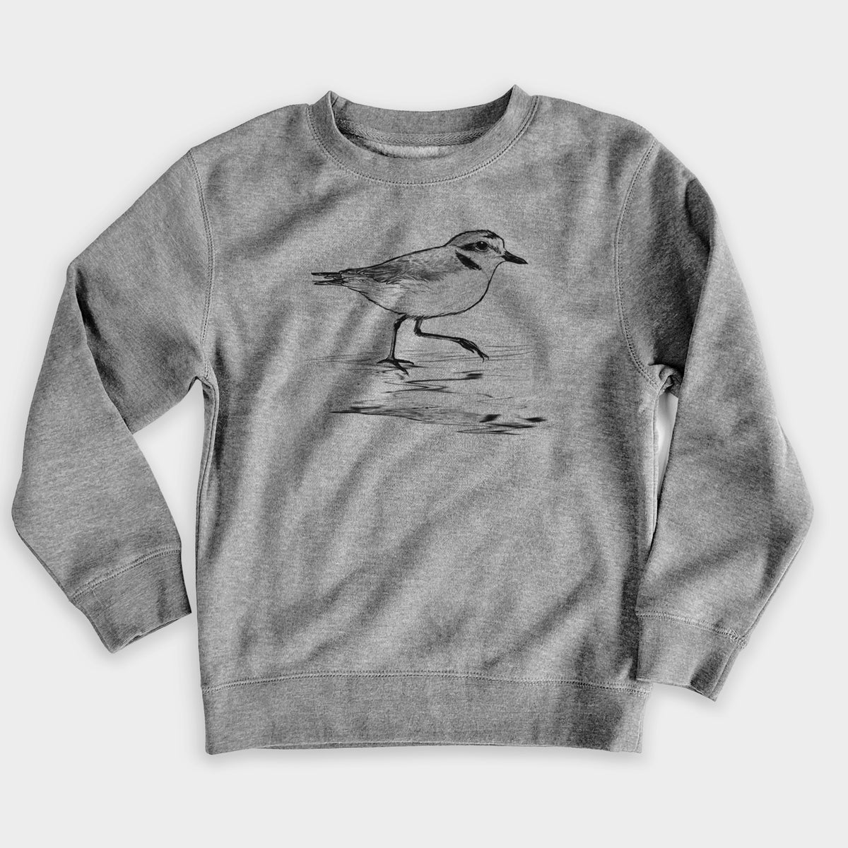 Nickel grey youth crewneck sweatshirt laid flat, printed with a black ink sketch of a snowy plover running along the wet shoreline.