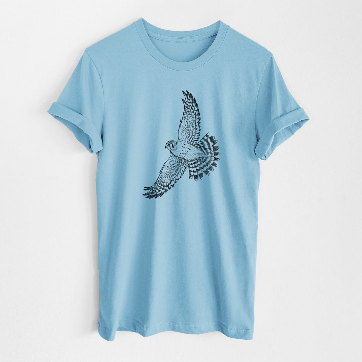 Ocean blue lightweight cotton t-shirt laid flat, printed with a detailed black ink illustration of an American kestrel in flight with its wings raised.