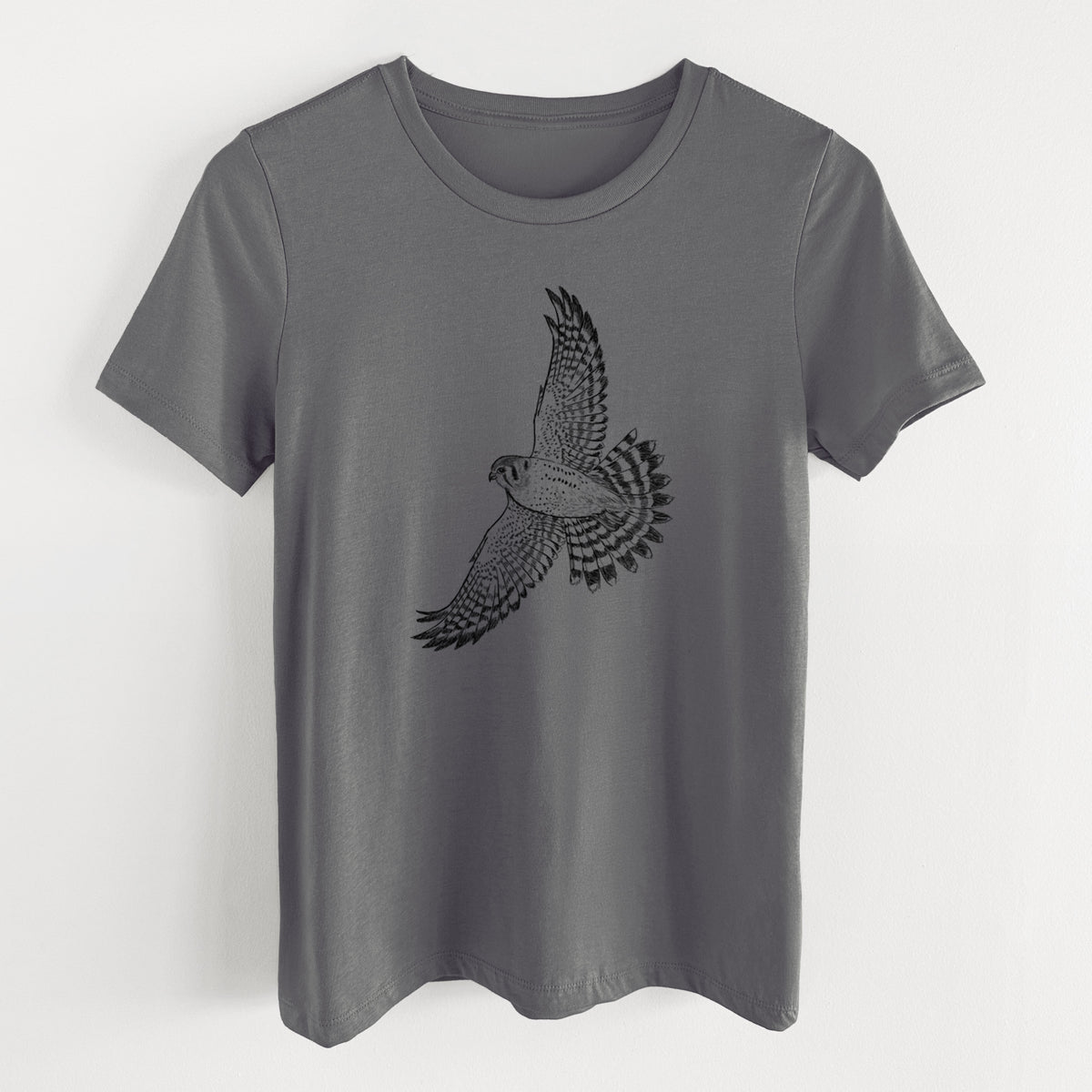 Asphalt women's relaxed fit cotton t-shirt laid flat, printed with a detailed black ink illustration of an American kestrel in flight with its wings raised.