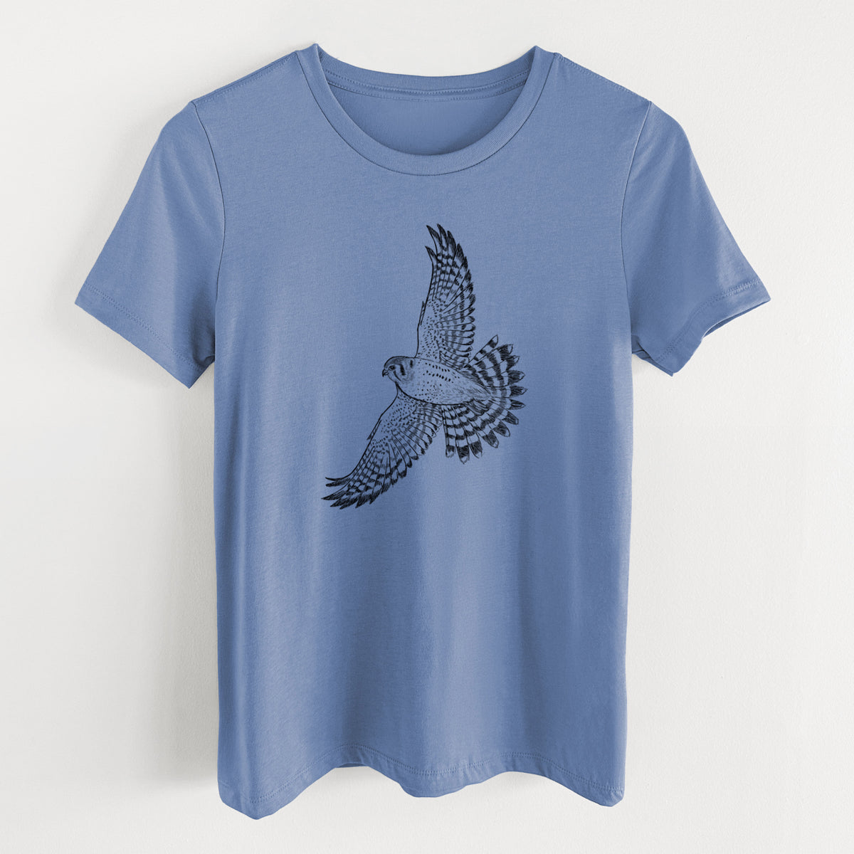 Blue bell women's relaxed fit cotton t-shirt laid flat, printed with a detailed black ink illustration of an American kestrel in flight with its wings raised.