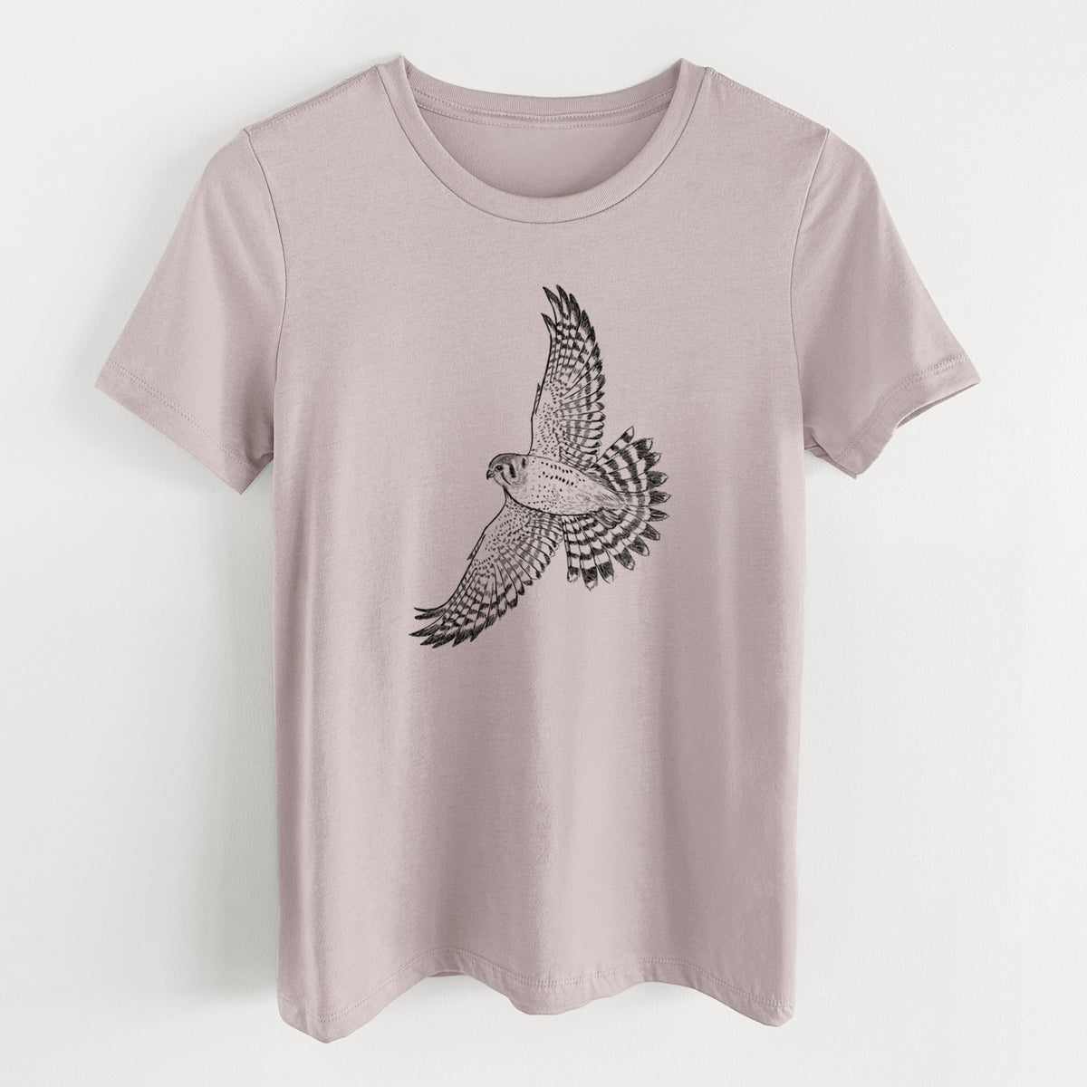 Pink gravel women's relaxed fit cotton t-shirt laid flat, printed with a detailed black ink illustration of an American kestrel in flight with its wings raised.