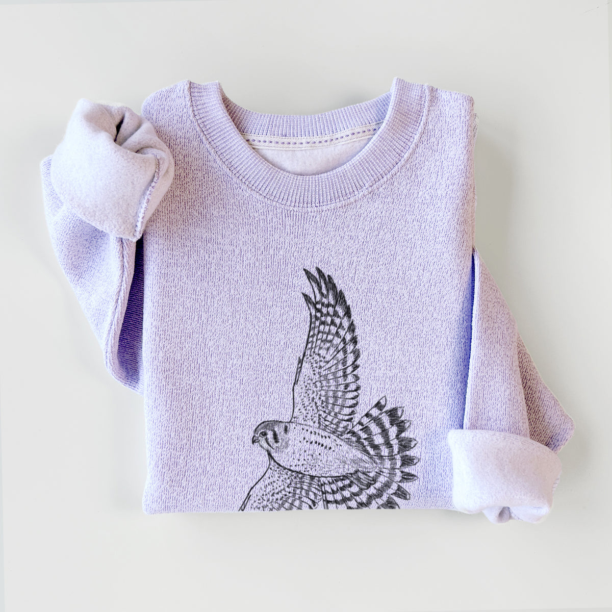 Ice purple knit sweatshirt printed with a detailed black ink illustration of an American kestrel in flight with its wings raised, styled flat.