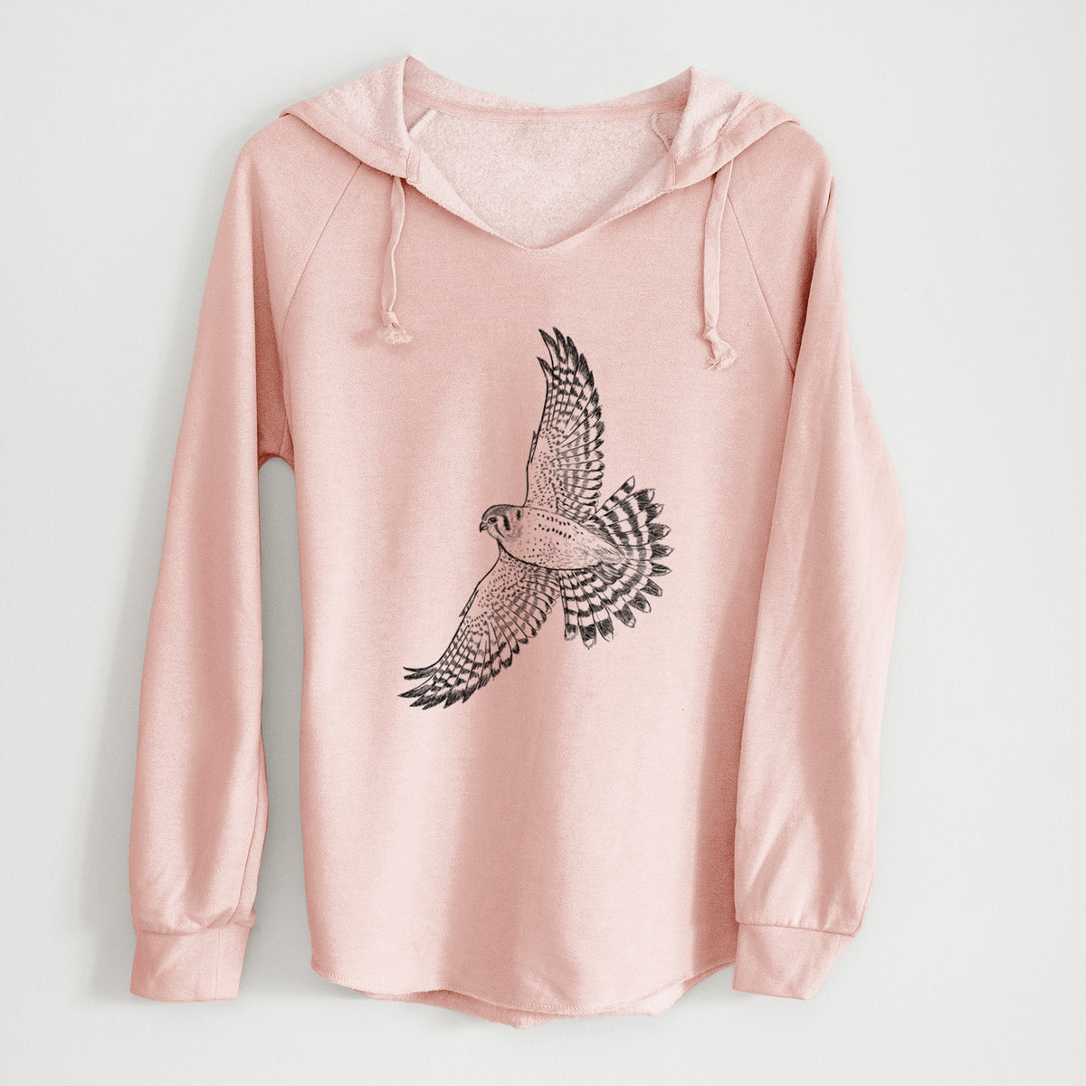 Blush pink women's Cali Wave hooded sweatshirt laid flat, printed with a detailed black ink illustration of an American kestrel in flight with its wings raised.