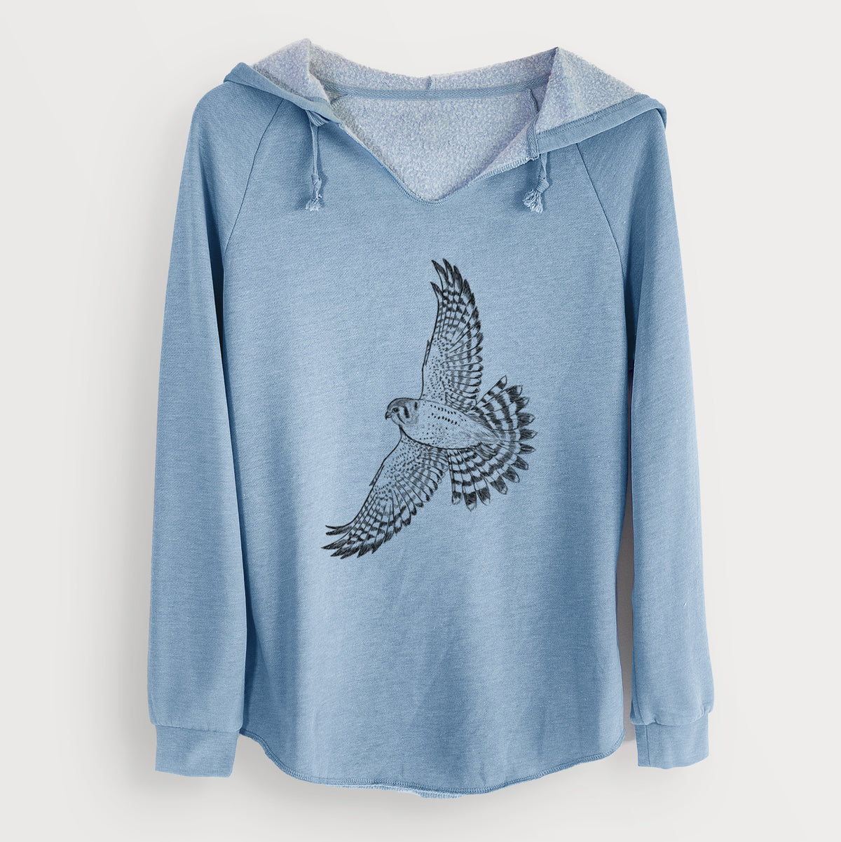 Misty blue women's Cali Wave hooded sweatshirt laid flat, printed with a detailed black ink illustration of an American kestrel in flight with its wings raised.