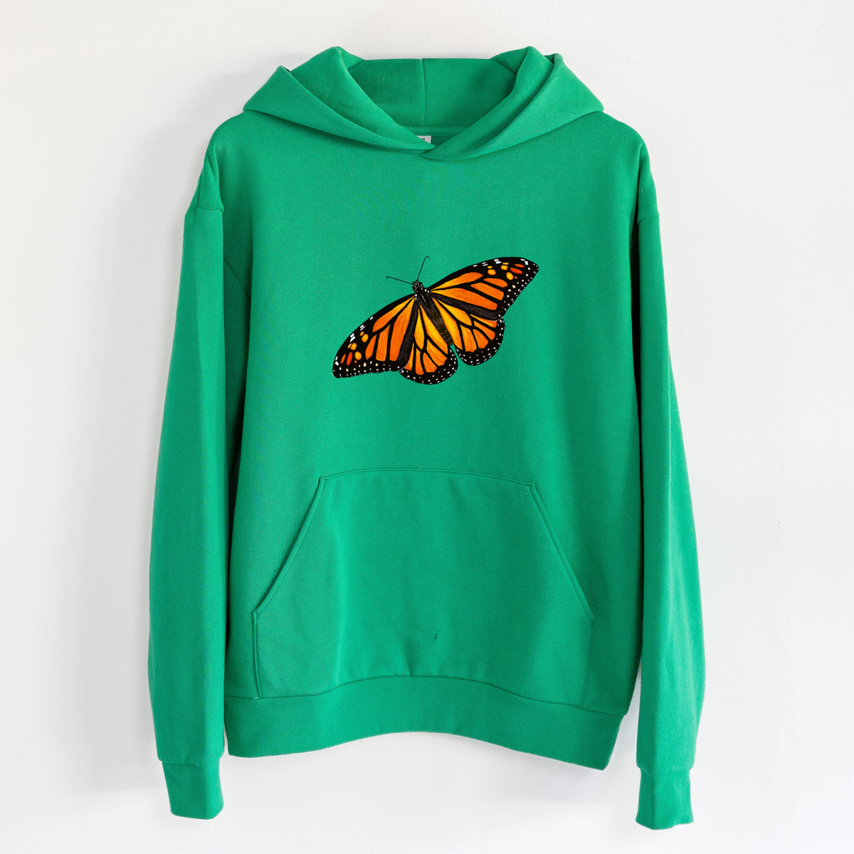 Vibrant Monarch - Danaus plexippus - Statement Midweight Hoodie in Kelly Green, hanging on a white wall, with a front kangaroo pocket and no drawcords.