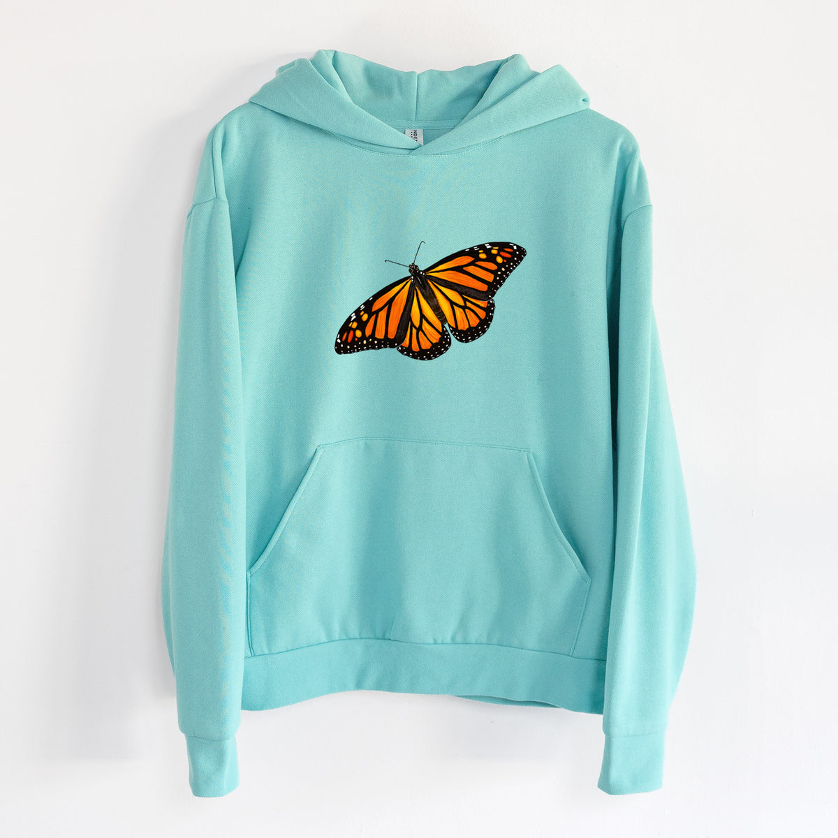Vibrant Monarch - Danaus plexippus - Statement Midweight Hoodie in Seafoam, hanging on a white wall, with a front kangaroo pocket and no drawcords.