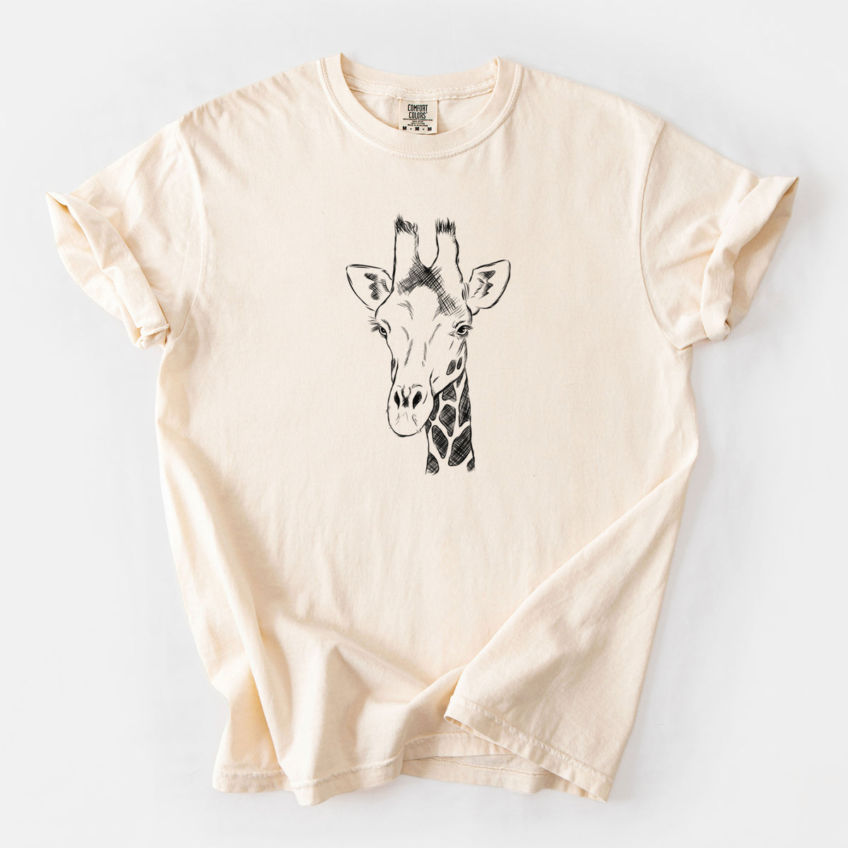 Ivory Comfort Colors t-shirt laid flat, printed with a black ink portrait of a southern giraffe's head and neck.