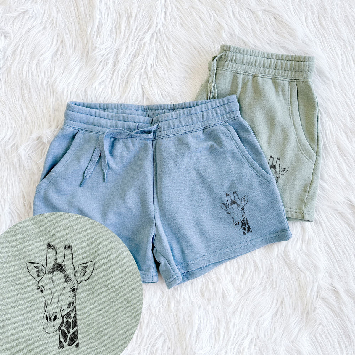 Two pairs of Cali Wave shorts in different colors printed with a black ink portrait of a southern giraffe's head and neck, with a close-up of the print.