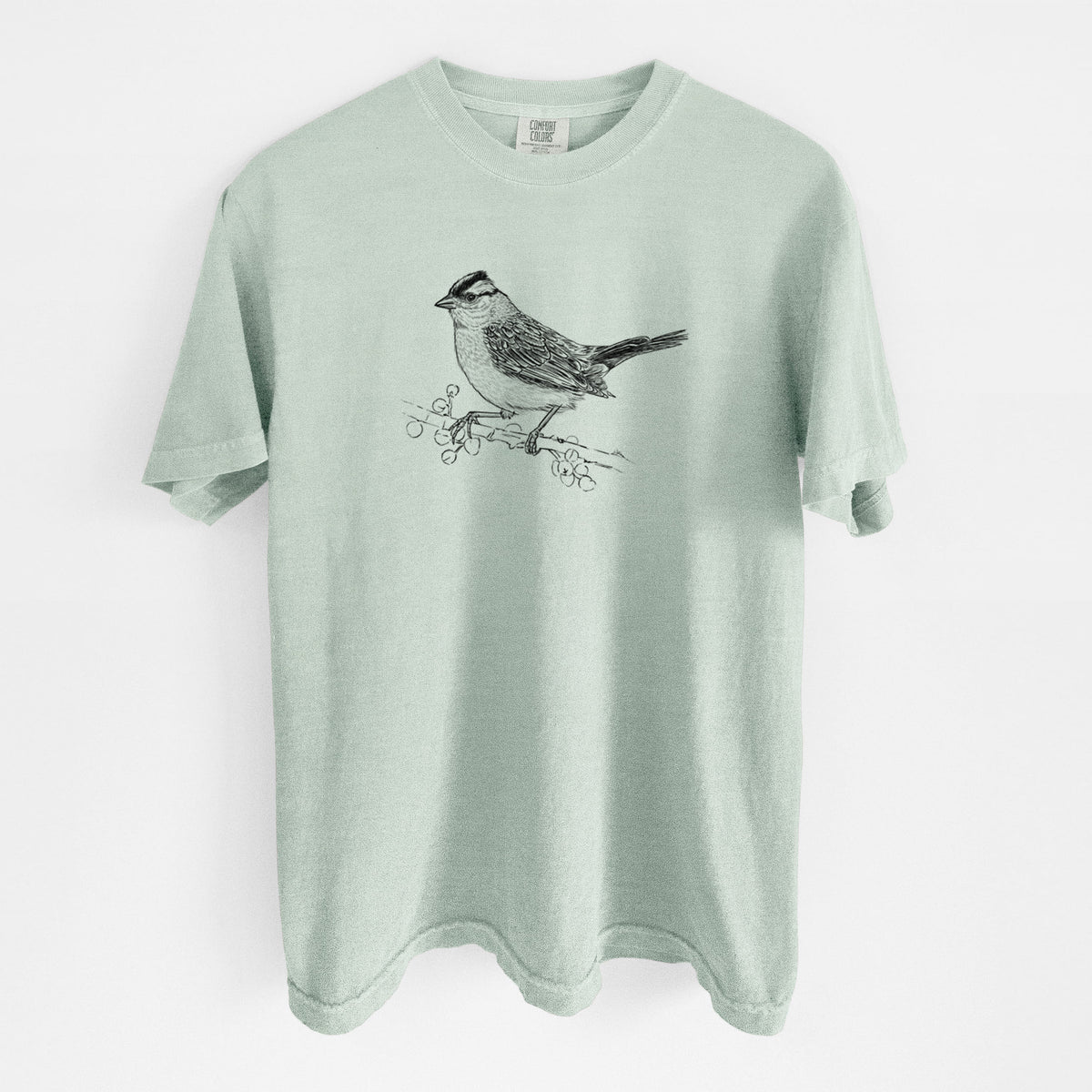 Bay green Comfort Colors t-shirt laid flat, printed with a detailed black ink sketch of a white-crowned sparrow perched on a branch.