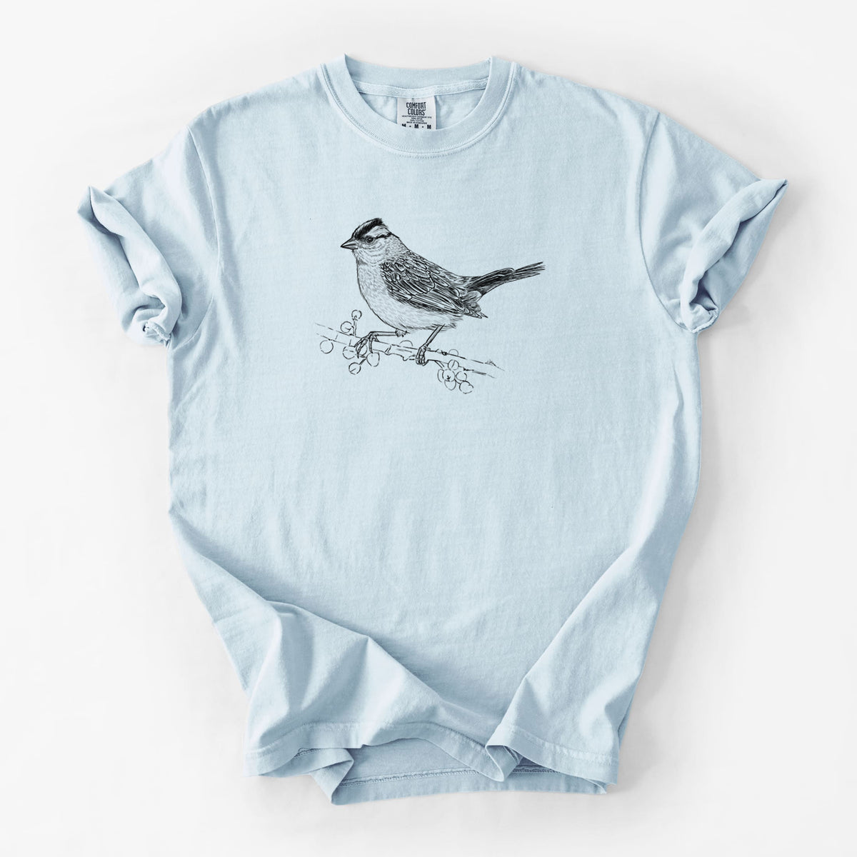 Chambray blue Comfort Colors t-shirt laid flat, printed with a detailed black ink sketch of a white-crowned sparrow perched on a branch.