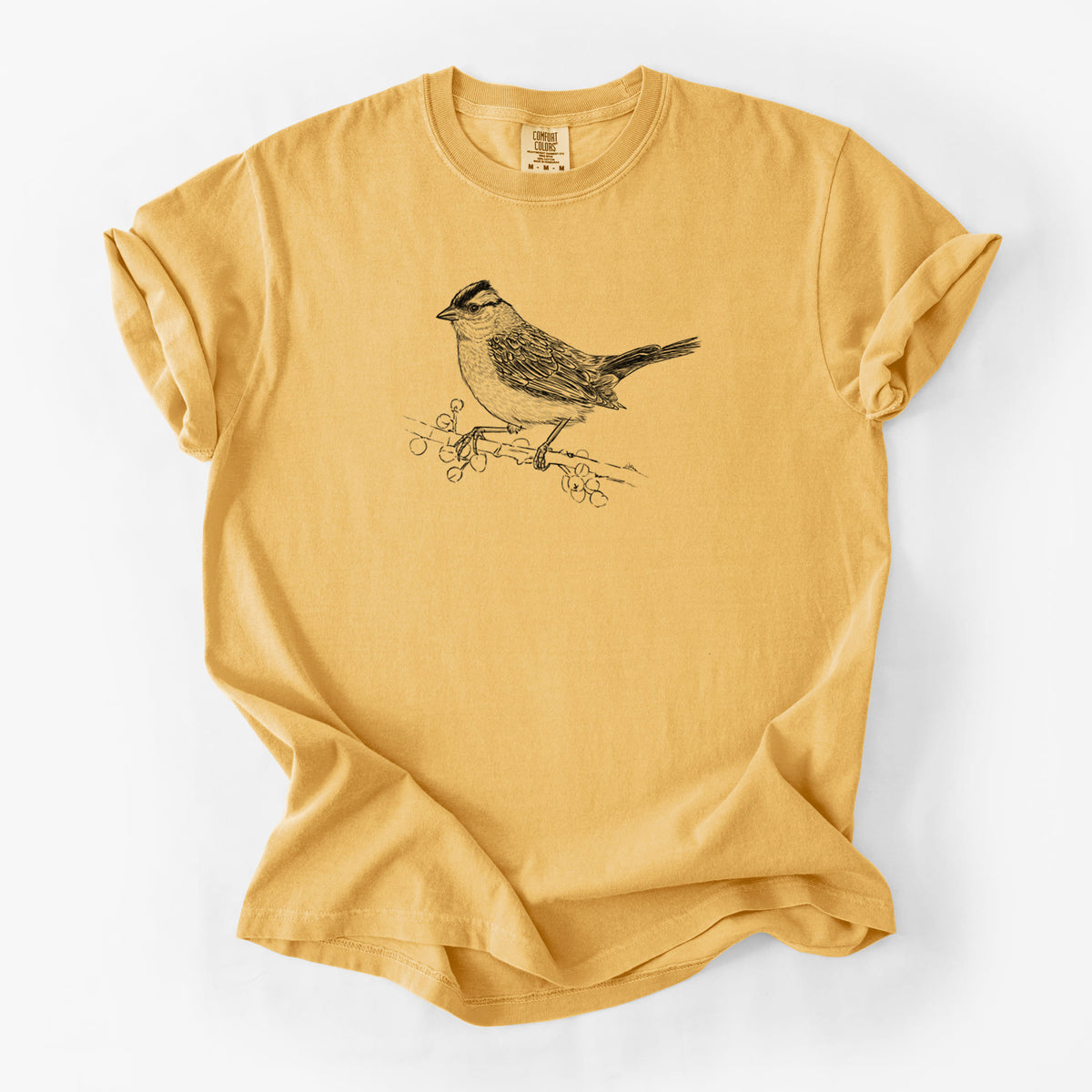 Golden wheat yellow Comfort Colors t-shirt laid flat, printed with a detailed black ink sketch of a white-crowned sparrow perched on a branch.