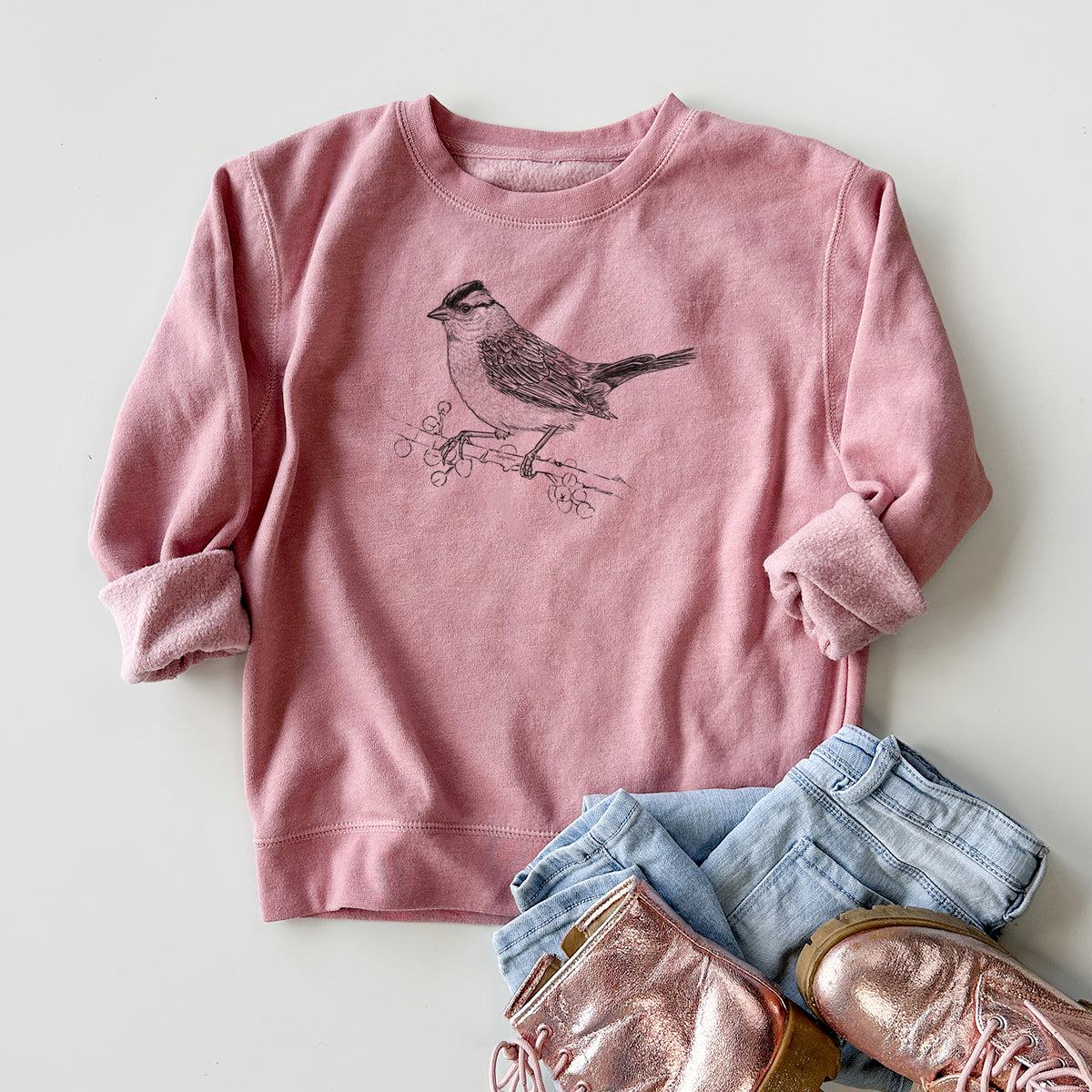 Youth crewneck sweatshirt printed with a detailed black ink sketch of a white-crowned sparrow perched on a branch, styled flat with jeans and boots.