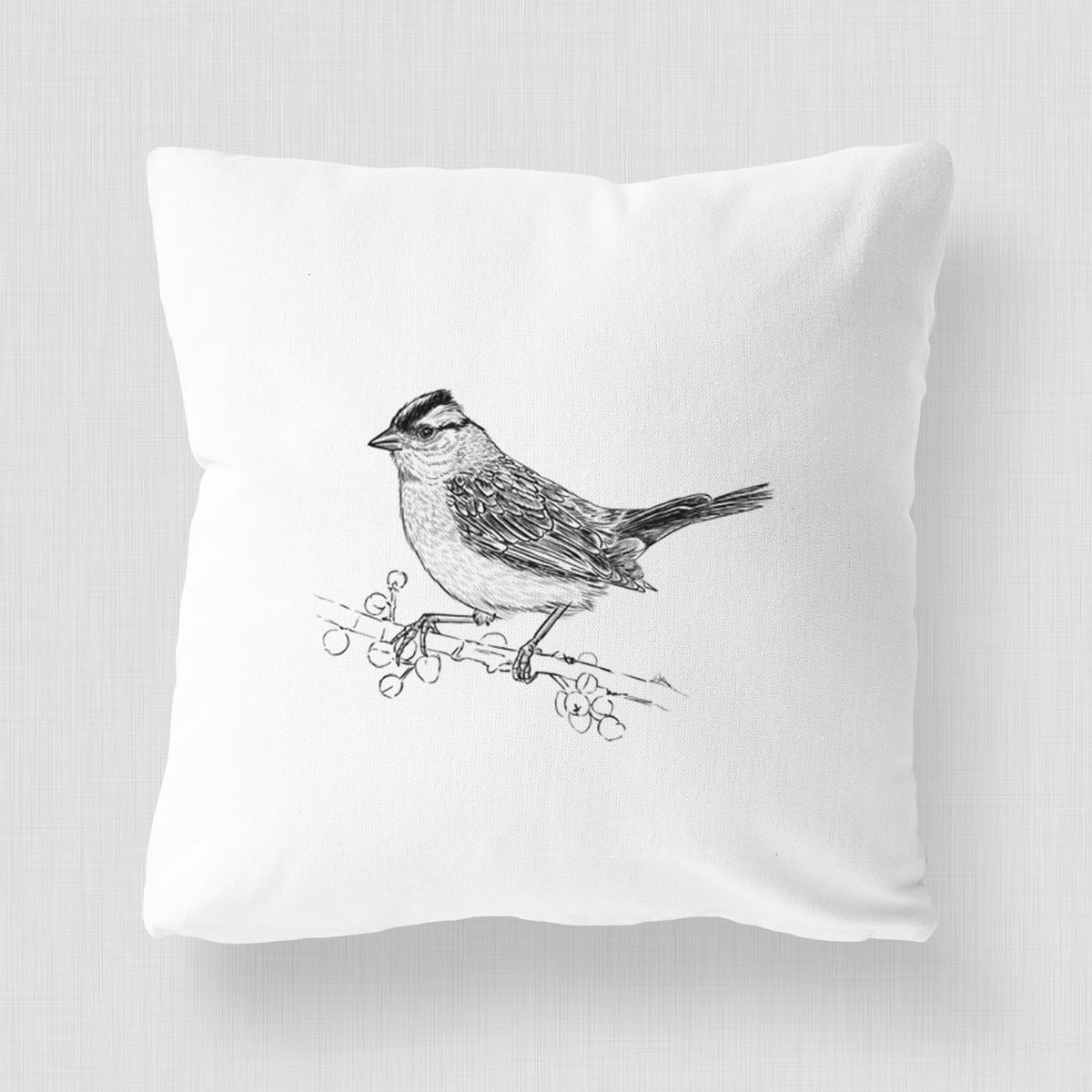 White pillow cover printed with a detailed black ink sketch of a white-crowned sparrow perched on a branch.