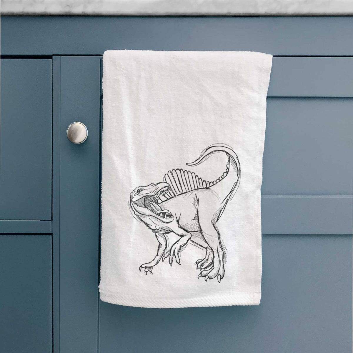 White hand towel printed with a black ink illustration of a Spinosaurus with its tall sail-shaped back.