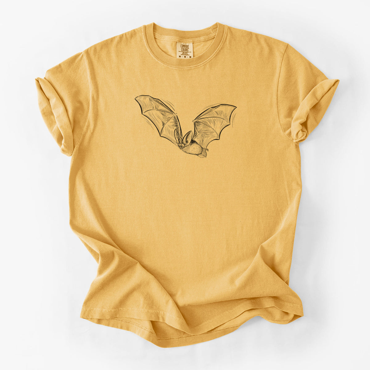 Golden wheat yellow Comfort Colors t-shirt laid flat, printed with a black ink illustration of a spotted bat in flight with large ears.