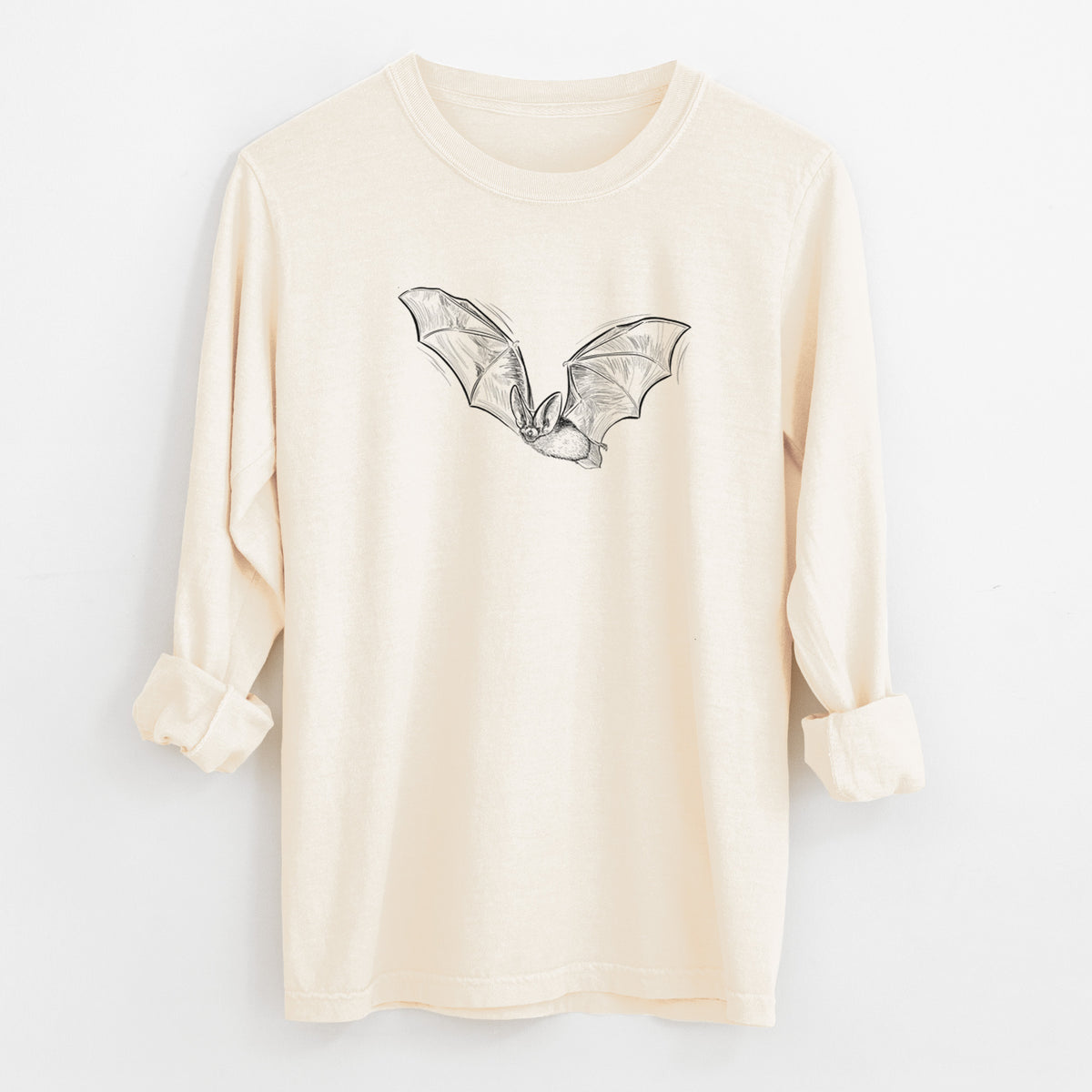 Ivory Comfort Colors long sleeve shirt laid flat with the cuffs rolled, printed with a black ink illustration of a spotted bat in flight with large ears.