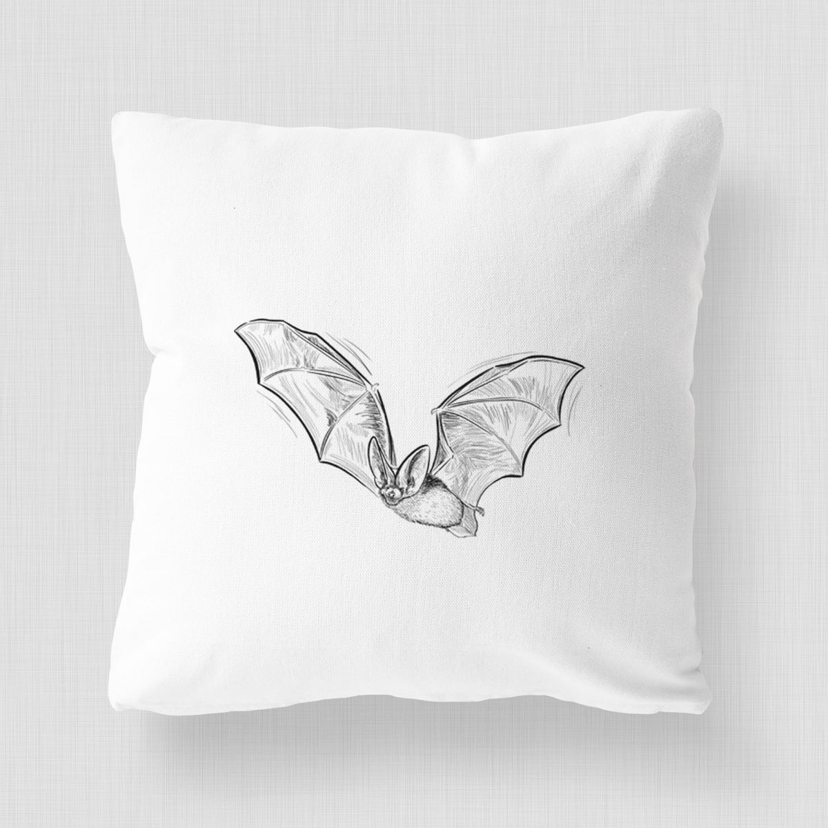 White pillow cover printed with a black ink illustration of a spotted bat in flight with large ears.