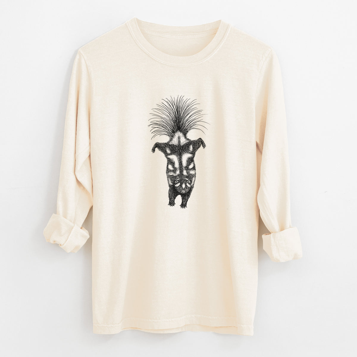 Ivory Comfort Colors long sleeve shirt laid flat with the cuffs rolled, printed with a black ink illustration of a spotted skunk doing a handstand with its tail fanned.