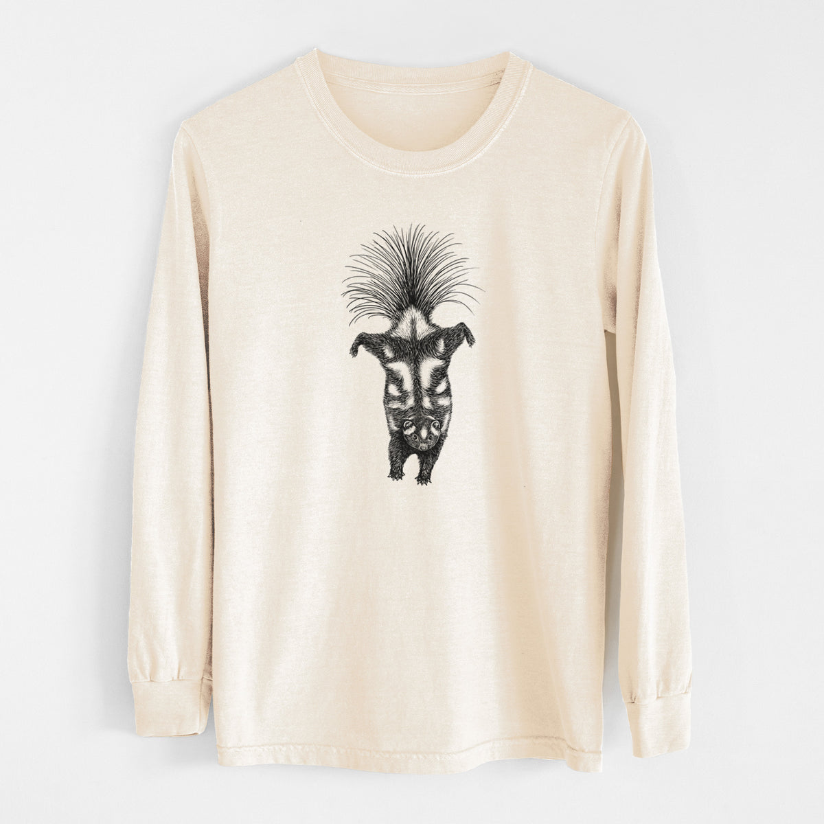 Ivory Comfort Colors long sleeve shirt laid flat, printed with a black ink illustration of a spotted skunk doing a handstand with its tail fanned.
