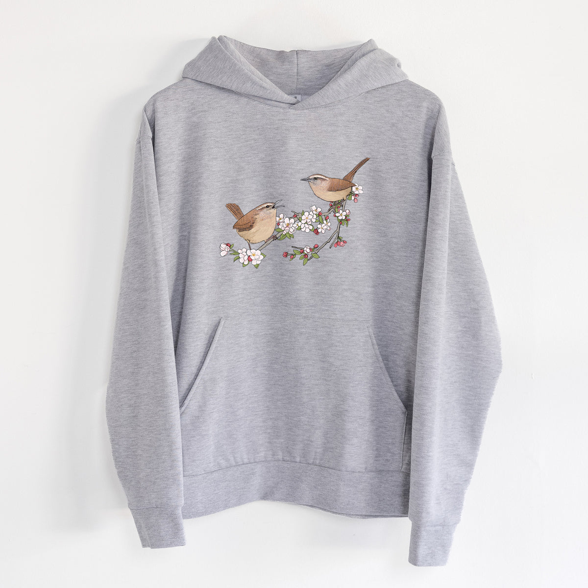 Spring Carolina Wrens on a Blooming Crabtree Branch - Statement Midweight Hoodie in Heather Grey, hanging on a white wall, with a front kangaroo pocket and no drawcords.