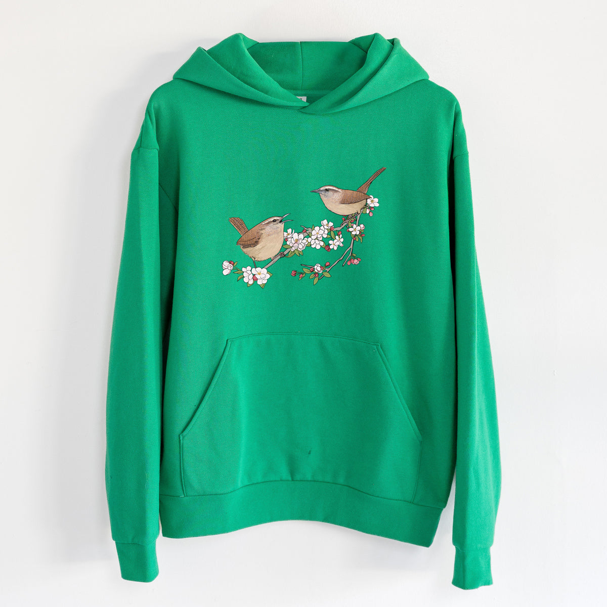 Spring Carolina Wrens on a Blooming Crabtree Branch - Statement Midweight Hoodie in Kelly Green, hanging on a white wall, with a front kangaroo pocket and no drawcords.