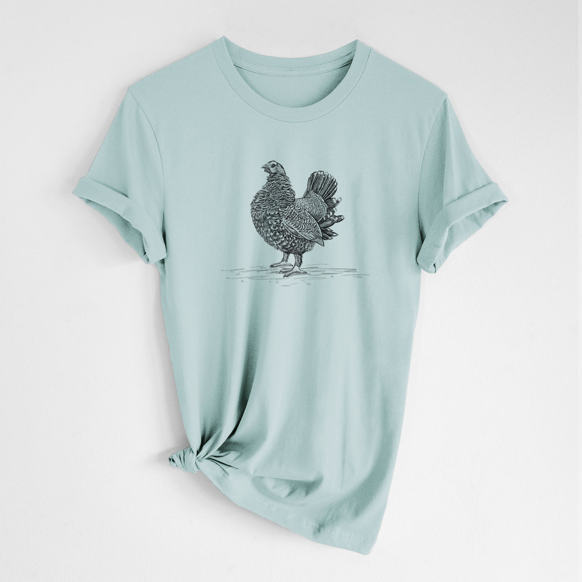 Dusty blue lightweight cotton t-shirt laid flat with the sleeves rolled, printed with a detailed black ink illustration of a spruce grouse standing with its tail fanned.