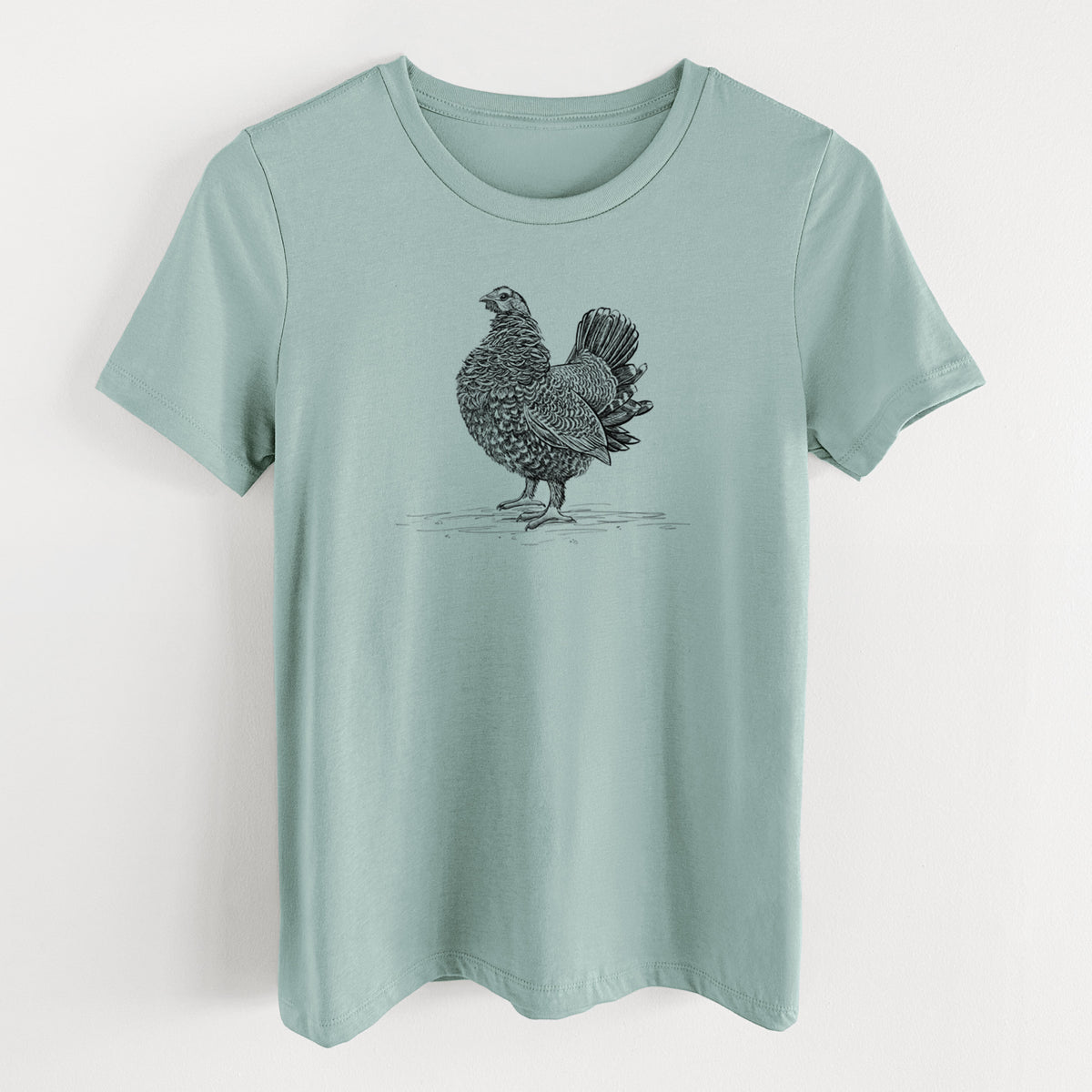 Dusty blue women's relaxed fit cotton t-shirt laid flat, printed with a detailed black ink illustration of a spruce grouse standing with its tail fanned.