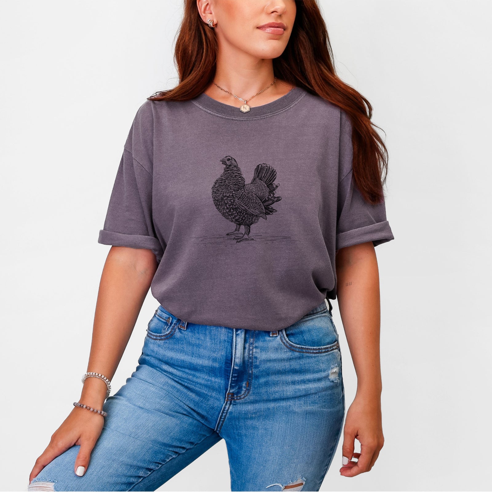 Blue jean Comfort Colors t-shirt laid flat, printed with a detailed black ink illustration of a spruce grouse standing with its tail fanned.